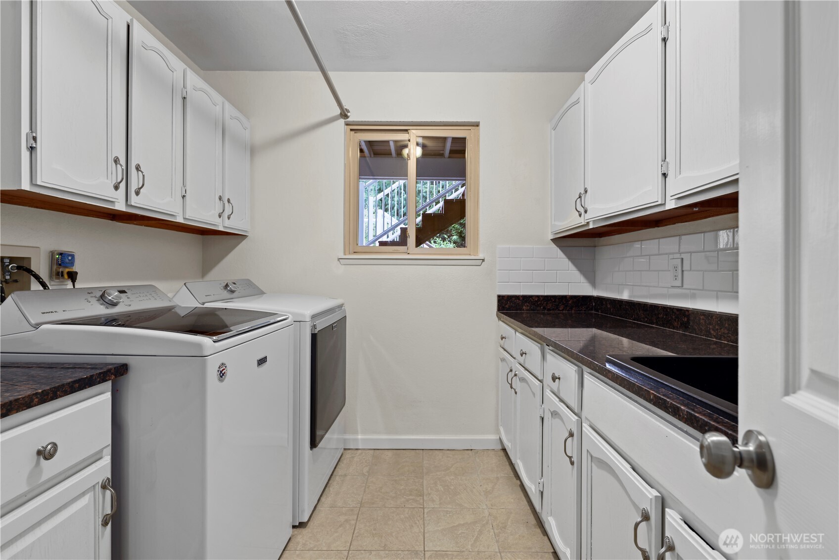 Laundry room at the base of the stairs includes a utility sink