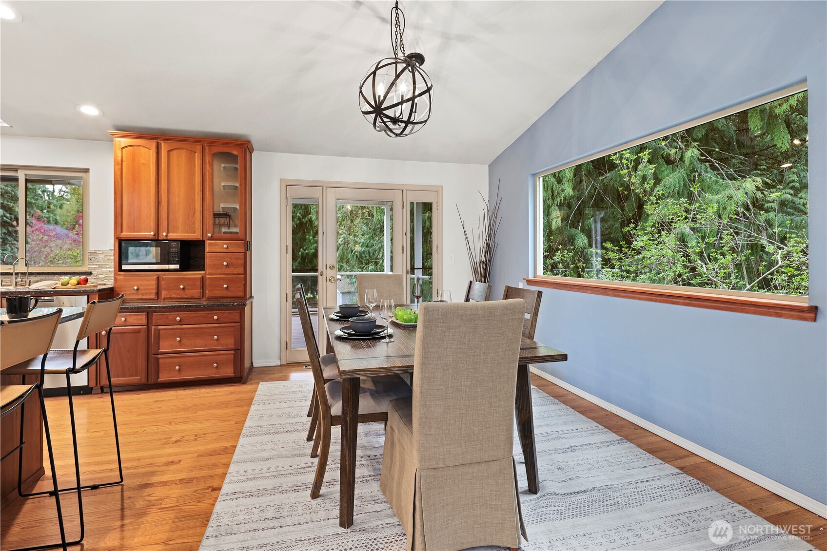 Window off the dining room features gorgeous wooded view; door goes out to the covered deck