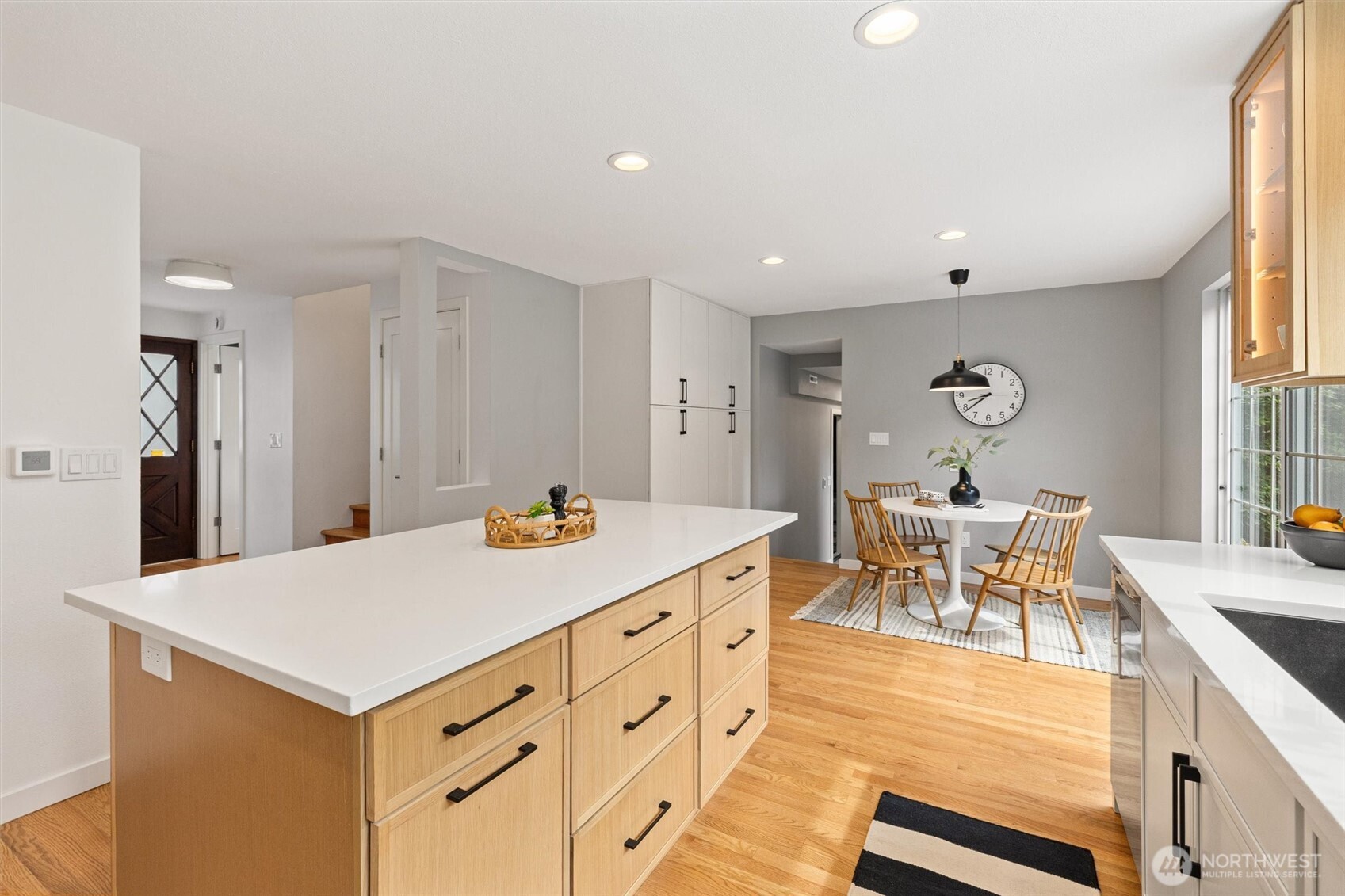The updated kitchen features sleek quartz countertops, stainless steel appliances,