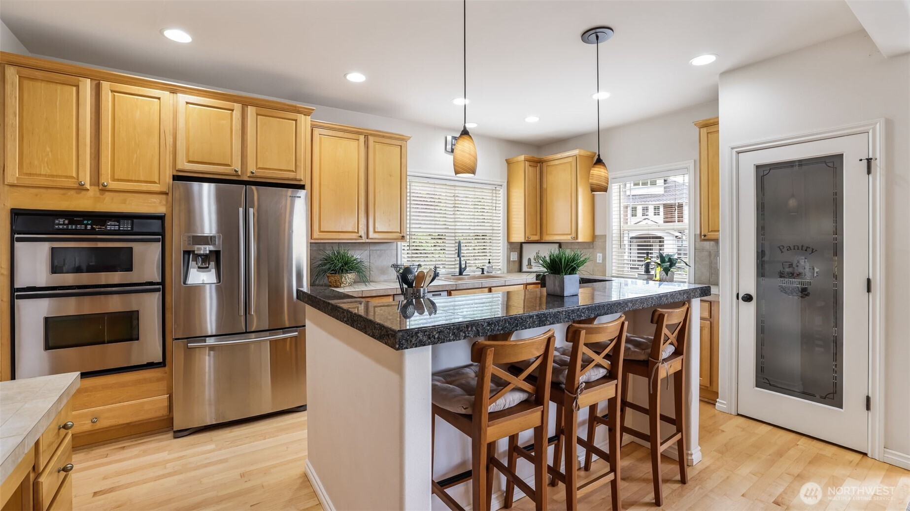 This kitchen features abundant cabinet storage and a stunning island with bar seating—perfect for entertaining.