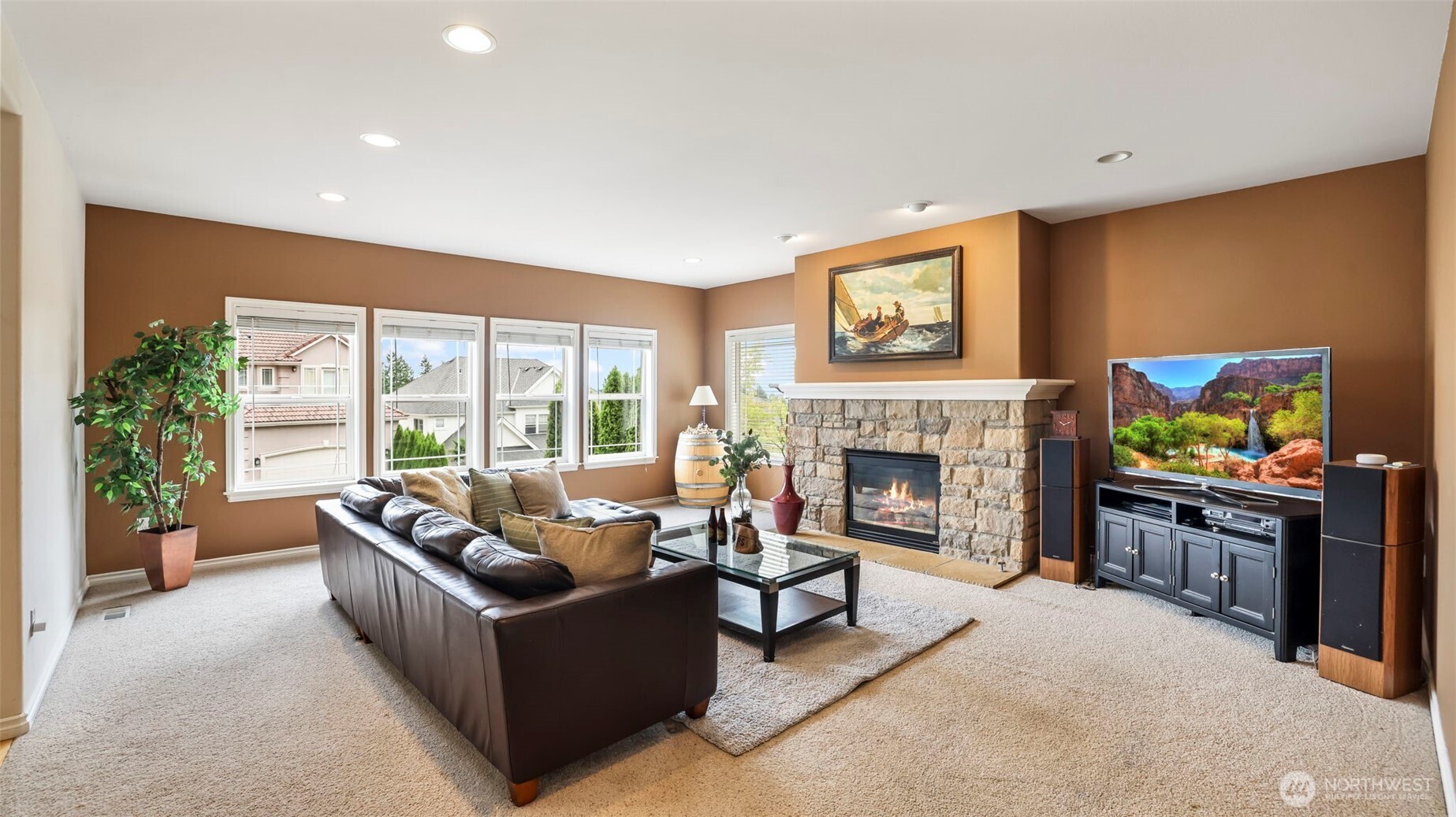 Enjoy this sun-filled living room with stone fireplace—perfect for relaxing or entertaining year-round.