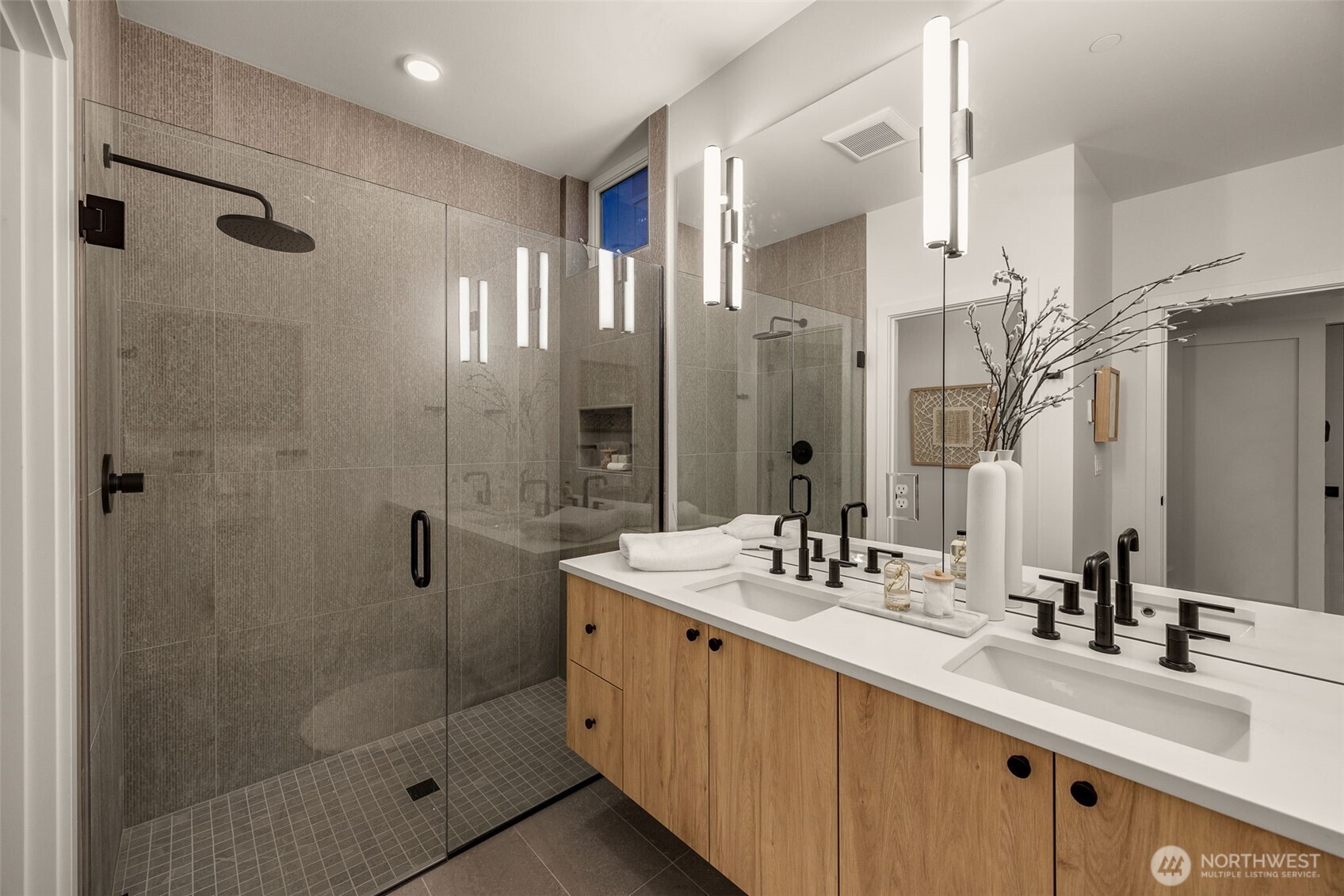 The priimary bath hosts a floating dual vanity & rain-fall showerhead