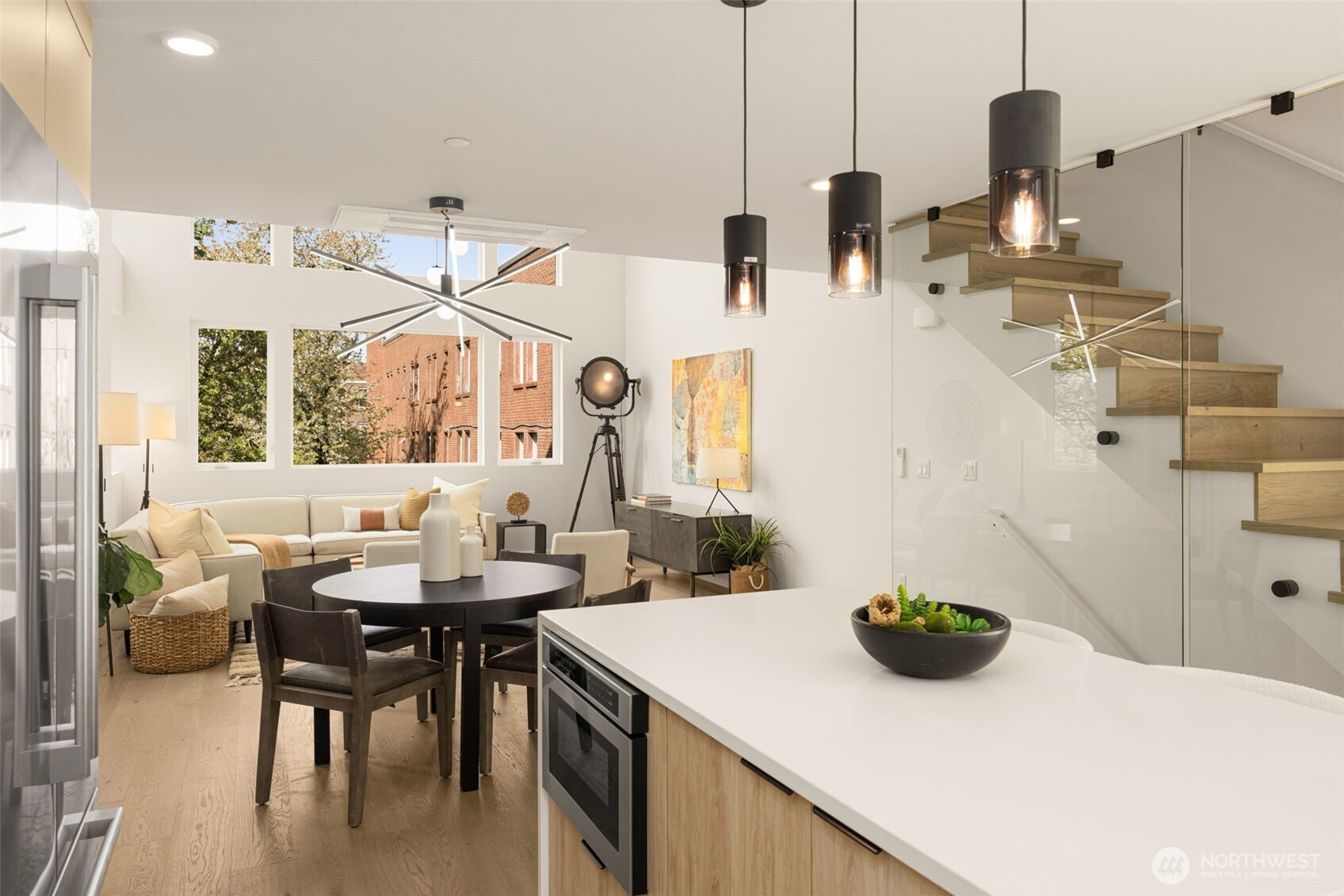 The high-design aesthetic is anchored by a luxury glass-walled staircase.