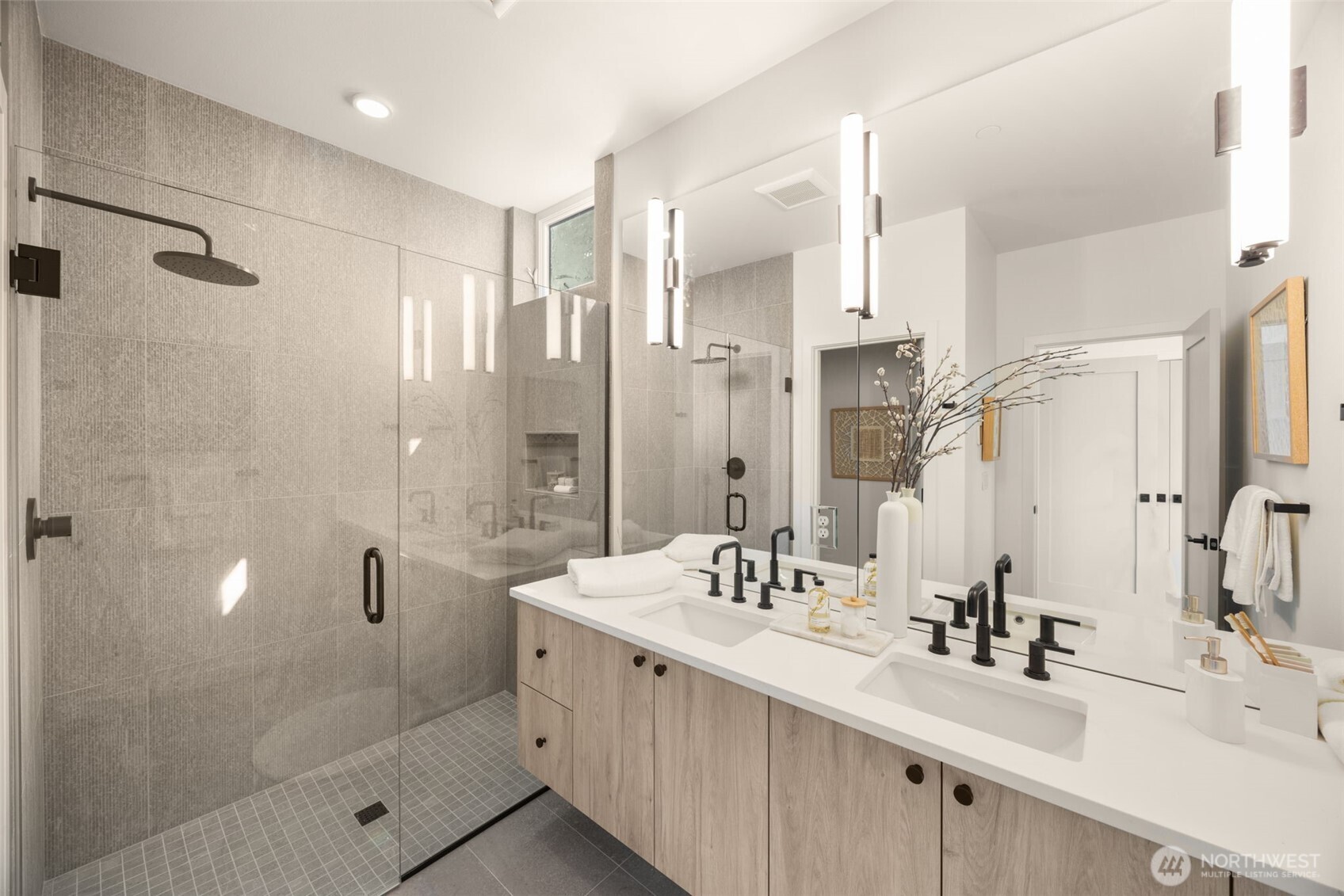The en-suite bath is a curated retreat with floor-to-ceiling tile and spa finishes.
