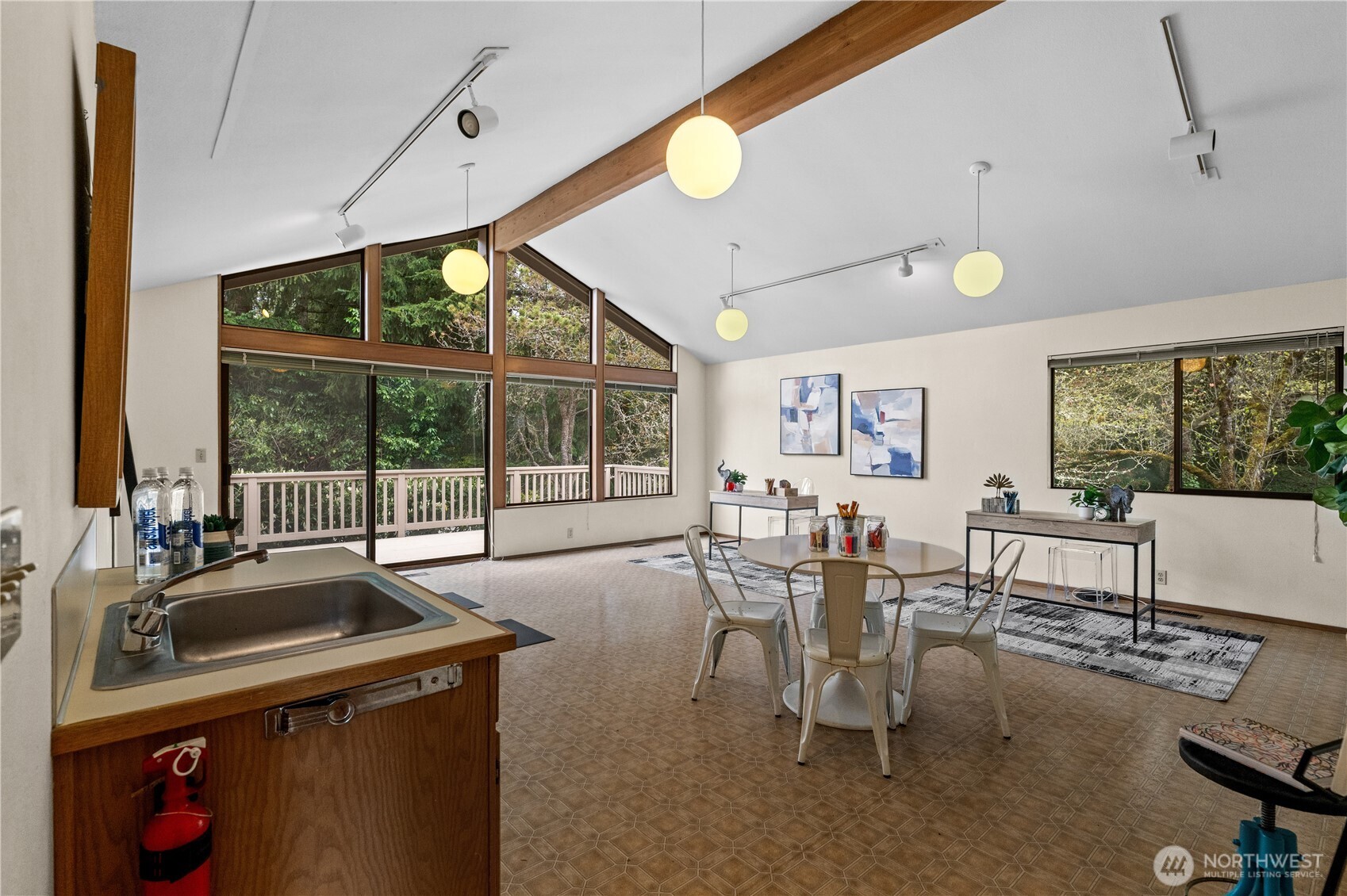 A jaw-dropping oversized bonus room is a standout and features an open beam ceiling and mid-century style light fixtures.