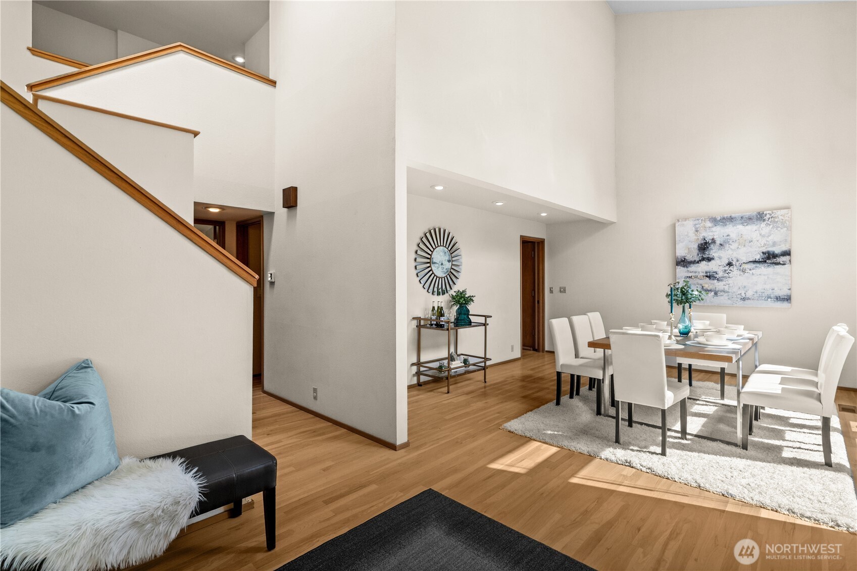 The foyer is flanked by impressive dining and living rooms.  A staircase accesses the upper floor bedrooms.