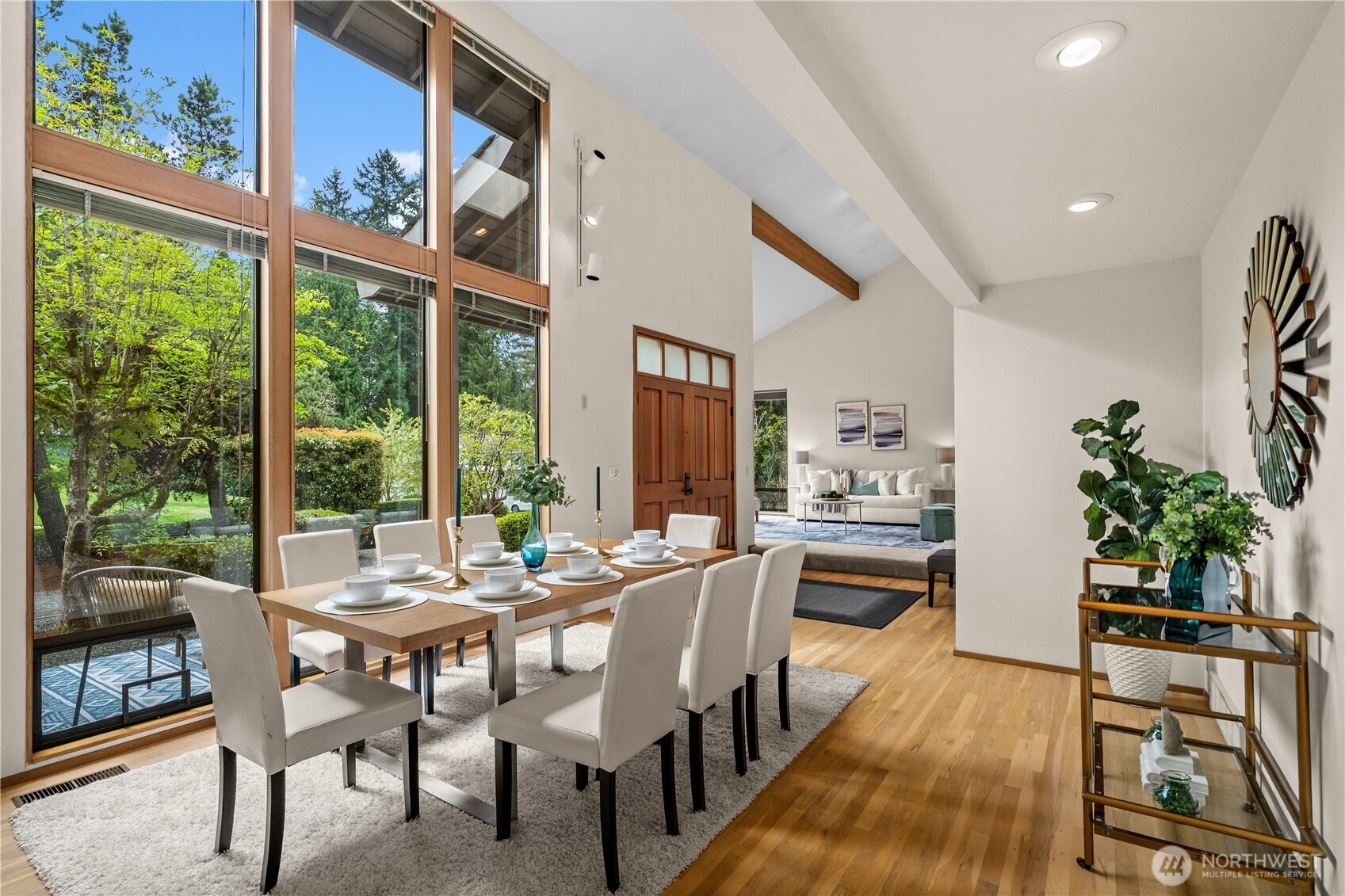 Floor to ceiling windows overlook the delightful lush green views of the front yard - like bringing the outdoors in .