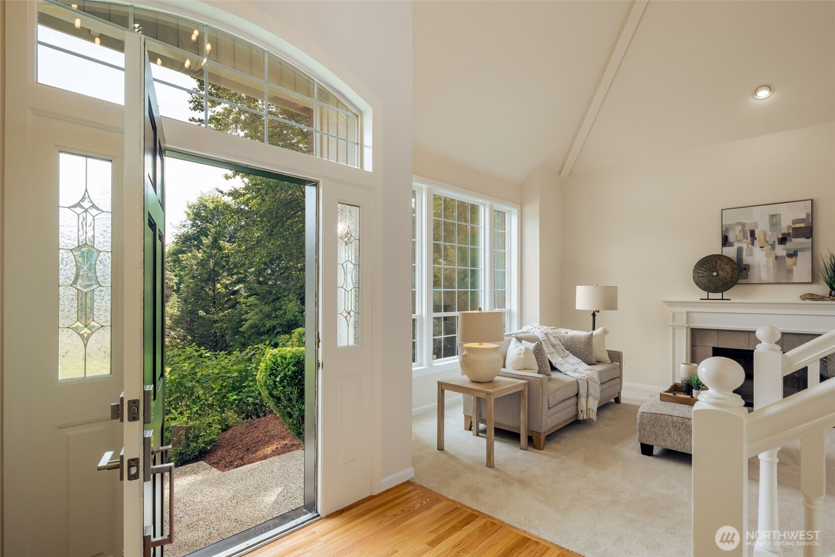 View from the living room to the dramatic entry featuring a designer entry light fixture!