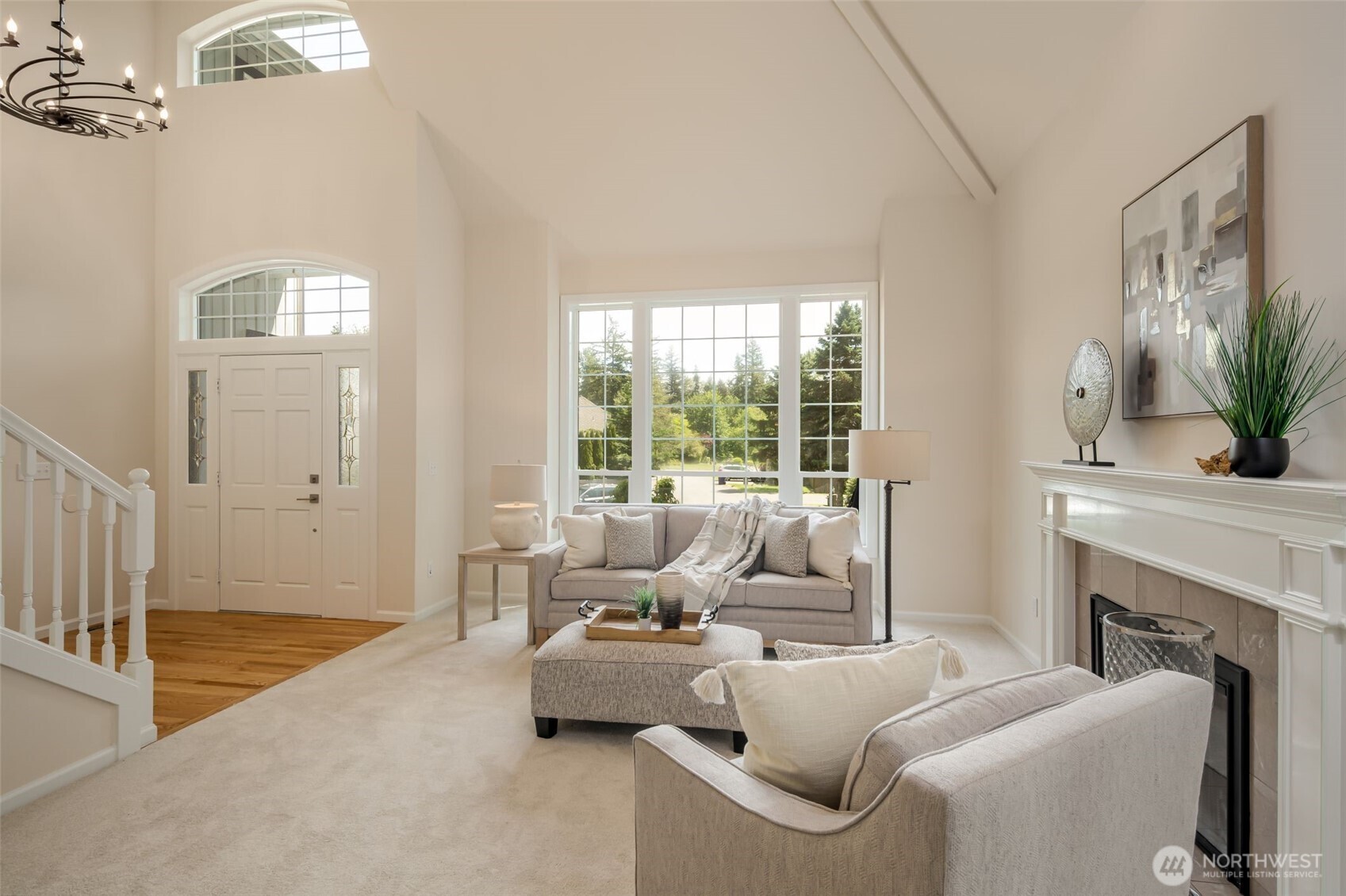View of the living room featuring soaring ceilings and gas fireplace.