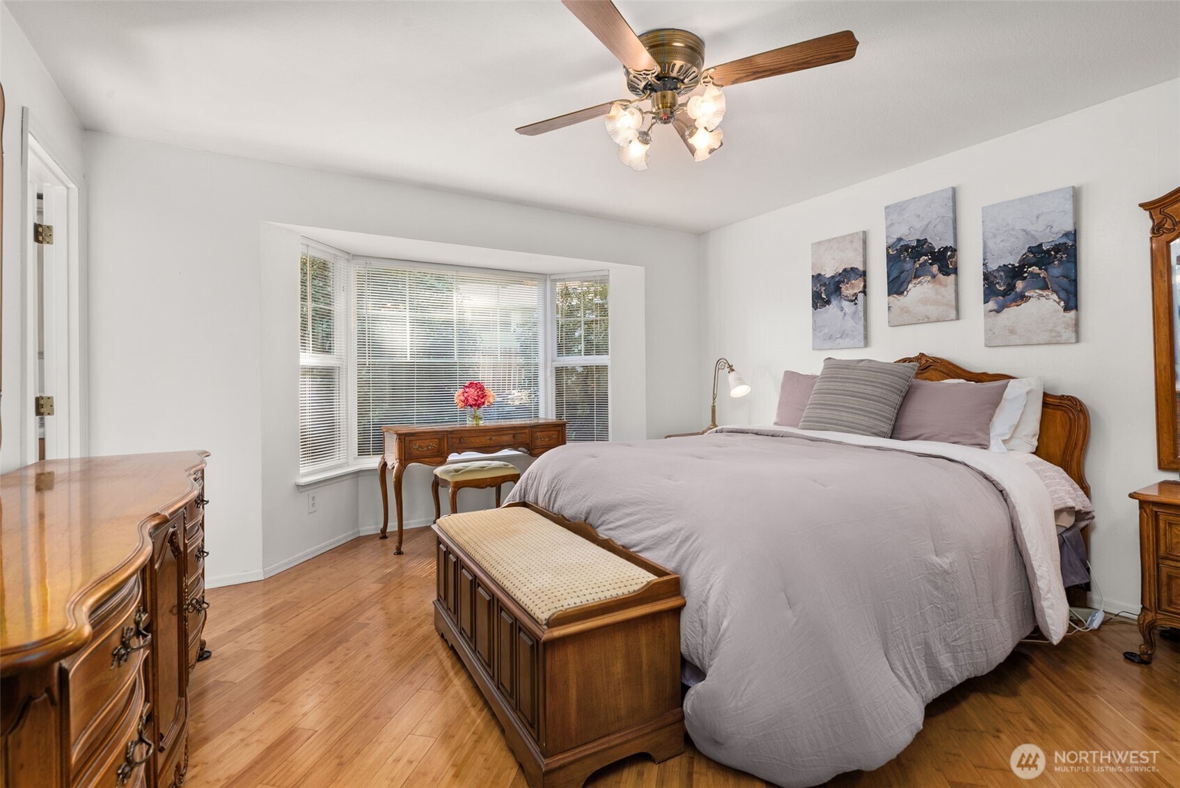 The newer flooring extends into the bedrooms. Fan and bay window are nice touches.