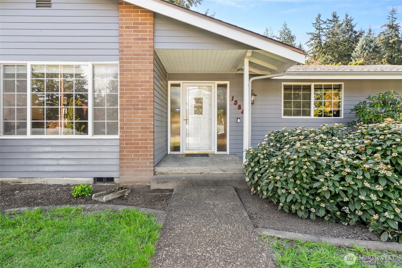 Side lights at the front door plus a storm door make for a lovely entry