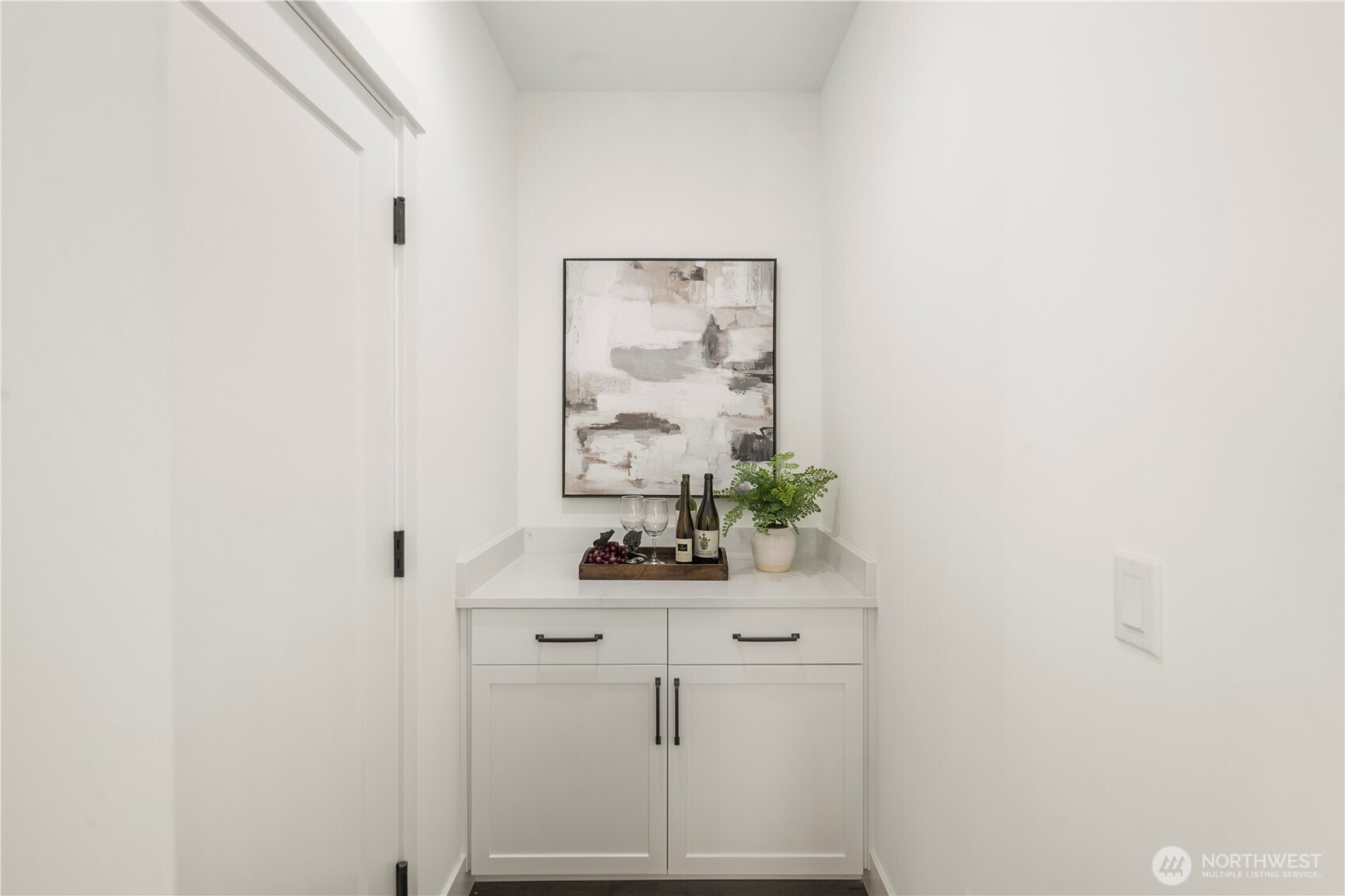 Garage Entry “Drop Zone” Area:  Just inside the garage entry, this versatile drop zone provides a practical transition space designed for organization and everyday convenience. Built-in cabinetry and counter space make it ideal for device charging, organizing bags and gear, or even creating a compact coffee station or bar setup. Located in Bothell’s Canyon Park neighborhood, the home supports active lifestyles with nearby parks, trails, and commuter routes that keep daily routines moving smoothly. The clean finishes and smart layout transform this functional area into an elevated extension of the main living spaces.    These photos are from Lot 5 at Gooden Hollow, the community model. The home listed will have changes, so all photos, renderings, site maps, and floorplans are for visualization purposes only. Plans, colors, building orientation, finishes, home outlook, and other details can and WILL vary.