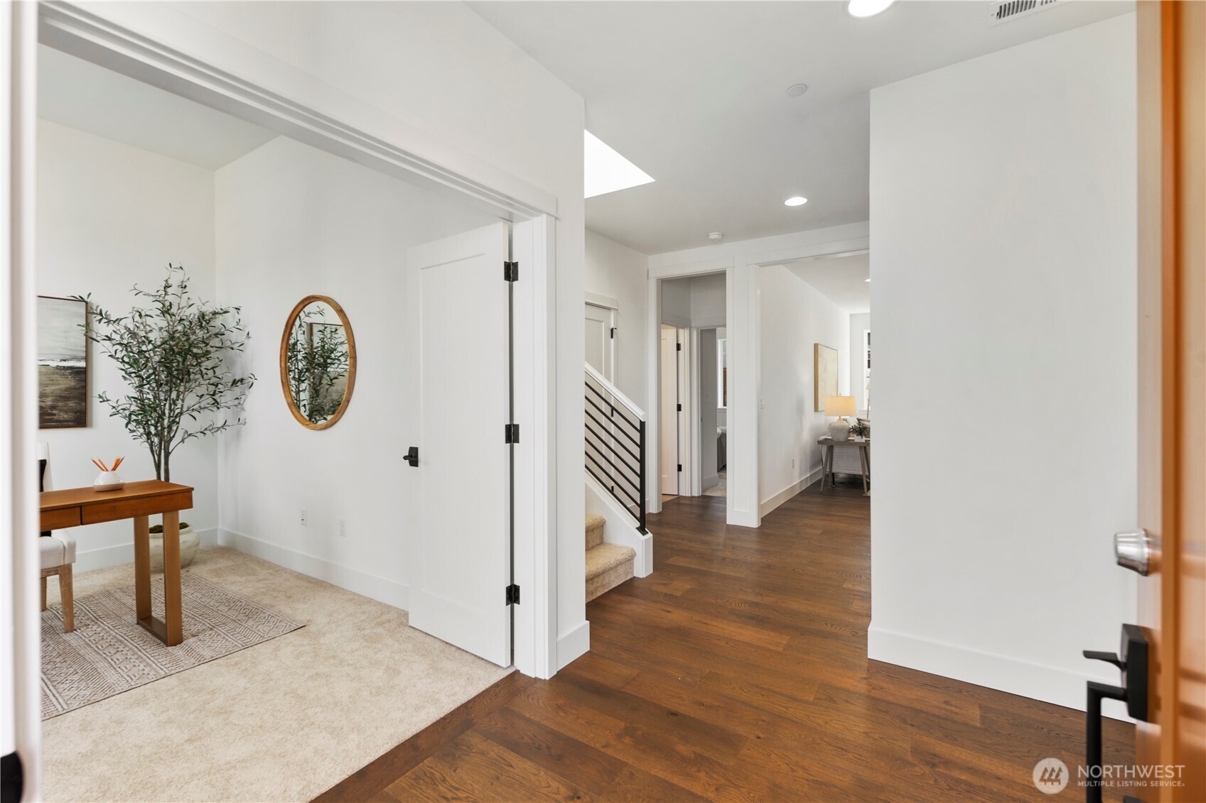 Entry & Hall (Featuring Office/Den):  The welcoming entry opens to a light-filled hallway accented by wood flooring and clean modern trim, creating a polished first impression. Just off the foyer, the main-level office/den offers immediate flexibility for remote work, meetings, or quiet focus while remaining connected to the heart of the home. Located within Bothell’s Canyon Park corridor, the home benefits from convenient access to parks, Northshore schools, and major commuter routes. The thoughtful sightlines and balanced proportions make this entry sequence feel open, organized, and seamlessly integrated into daily Northwest living.    These photos are from Lot 5 at Gooden Hollow, the community model. The home listed will have changes, so all photos, renderings, site maps, and floorplans are for visualization purposes only. Plans, colors, building orientation, finishes, home outlook, and other details can and WILL vary.