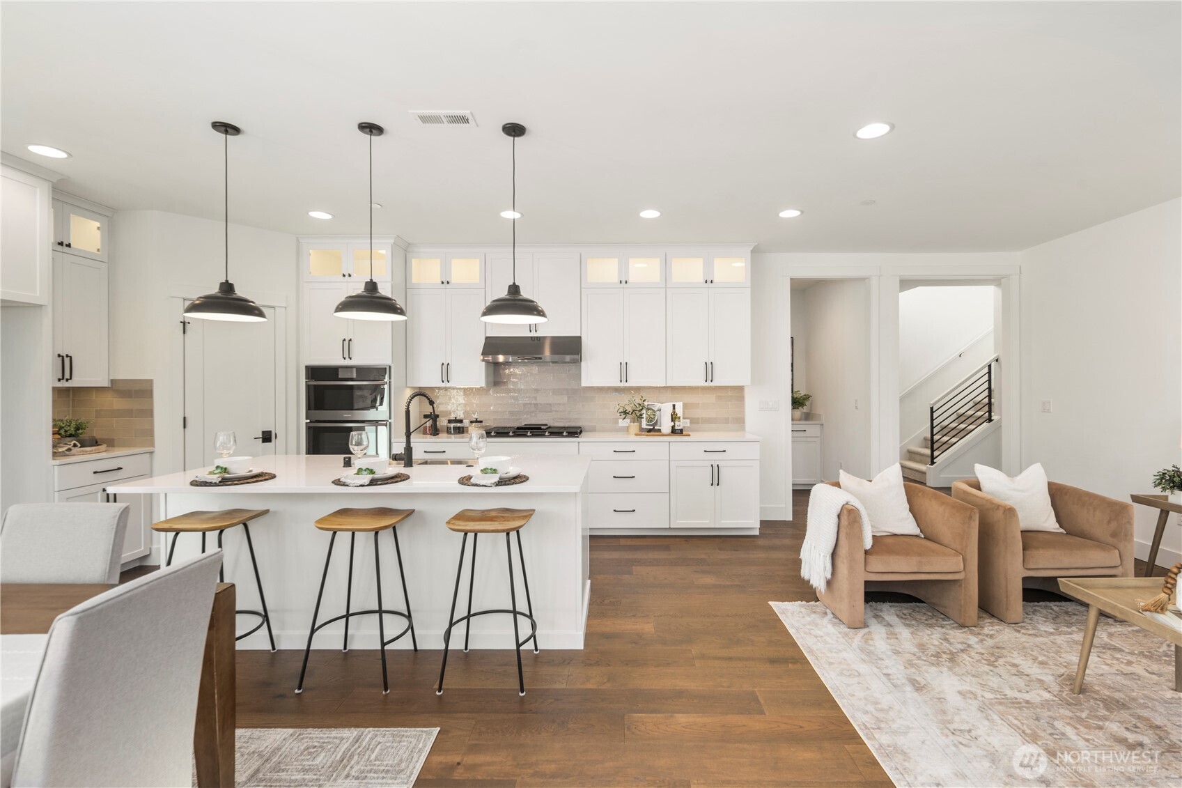 Kitchen:  This bright kitchen features white cabinetry, quartz countertops, a statement island with a farmhouse sink, and oversized pendant lighting that adds depth and visual balance. Its open layout supports cooking, gathering, and effortless movement between the main living areas. Positioned in Bothell’s Canyon Park neighborhood, the space benefits from proximity to local shopping, parks, and commuter routes, making daily routines streamlined and connected. Modern finishes, warm wood flooring, and thoughtful storage create a kitchen designed for both everyday ease and elevated hosting.    These photos are from Lot 5 at Gooden Hollow, the community model. The home listed will have changes, so all photos, renderings, site maps, and floorplans are for visualization purposes only. Plans, colors, building orientation, finishes, home outlook, and other details can and WILL vary.
