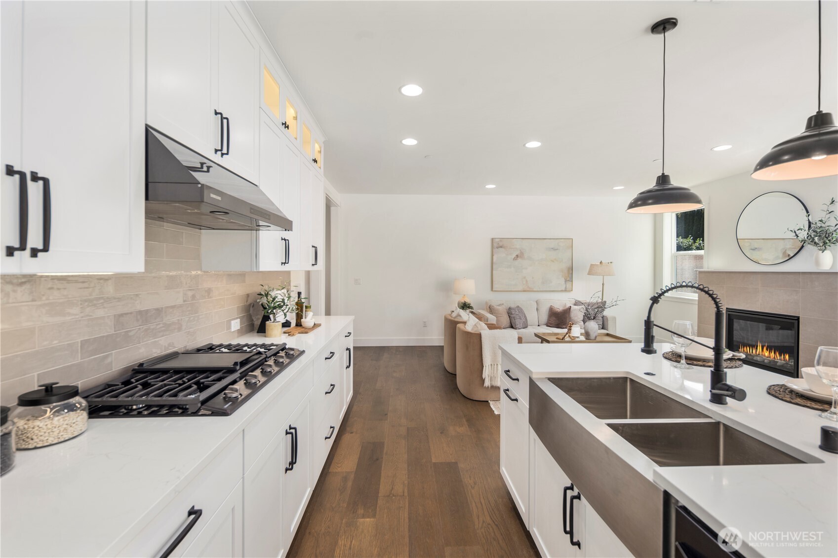 Kitchen Island:  A generous quartz island sits at the center of the kitchen, paired with matte black pendants that give the space a bold, contemporary feel. The island’s size and layout provide room for prep work, serving, or casual seating, all while keeping the cook connected to the rest of the main floor. With its location in Bothell’s sought-after Canyon Park corridor, daily errands, dining options, and Northshore schools are all close at hand. This island becomes a natural gathering point, blending function and design for effortless Northwest living.    These photos are from Lot 5 at Gooden Hollow, the community model. The home listed will have changes, so all photos, renderings, site maps, and floorplans are for visualization purposes only. Plans, colors, building orientation, finishes, home outlook, and other details can and WILL vary.