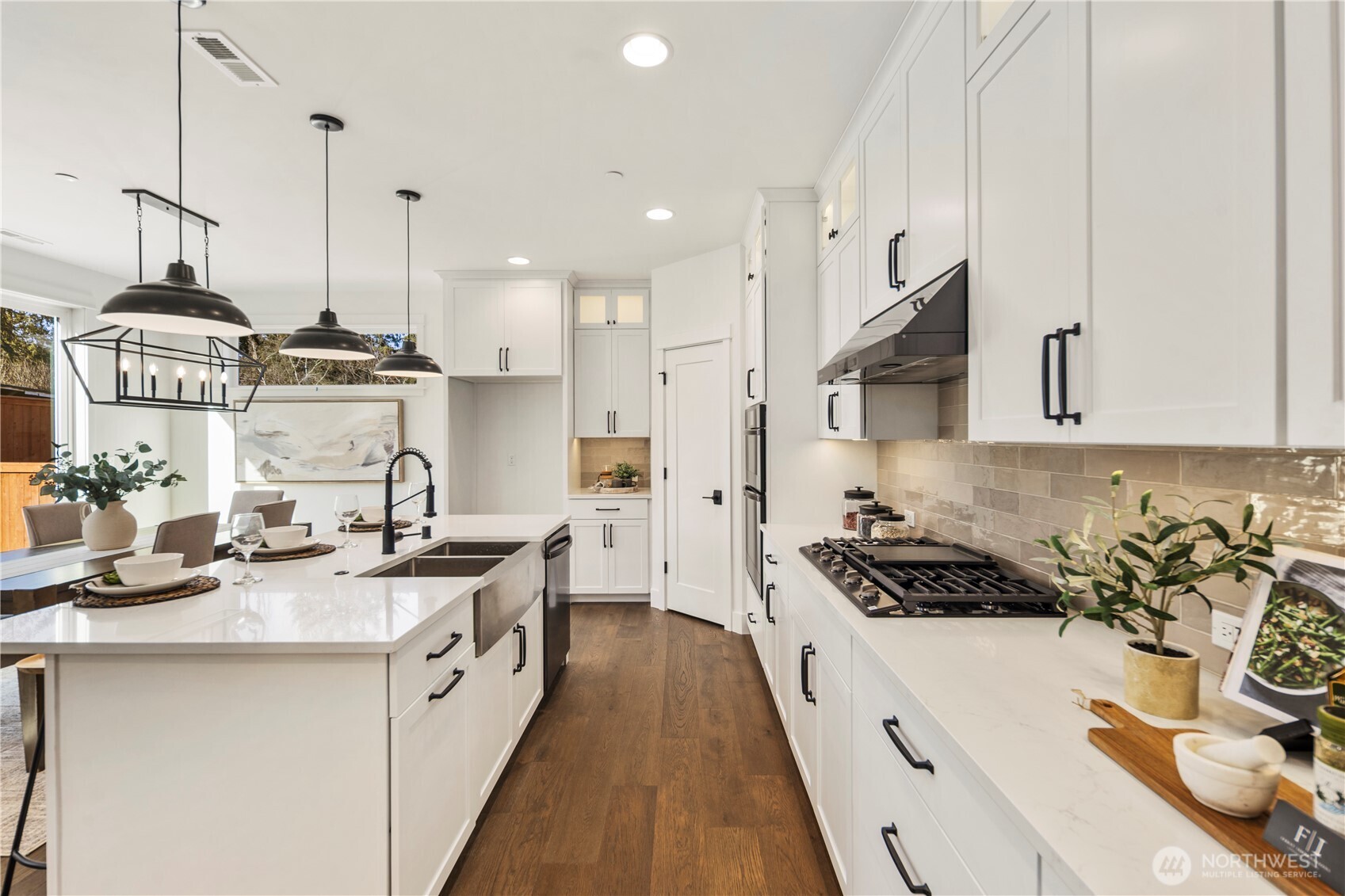 Kitchen Workspace:  This well-appointed kitchen features full-height shaker cabinetry, sleek quartz counters, and a modern tile backsplash that adds texture and warmth. The layout maximizes storage and prep space, keeping everything within easy reach while maintaining a streamlined aesthetic. As part of Bothell’s Canyon Park community, the home benefits from nearby parks, dining, and transit options that support a balanced Pacific Northwest lifestyle. Thoughtful lighting, upgraded appliances, and polished finishes elevate the space for both everyday cooking and more ambitious culinary projects.    These photos are from Lot 5 at Gooden Hollow, the community model. The home listed will have changes, so all photos, renderings, site maps, and floorplans are for visualization purposes only. Plans, colors, building orientation, finishes, home outlook, and other details can and WILL vary.