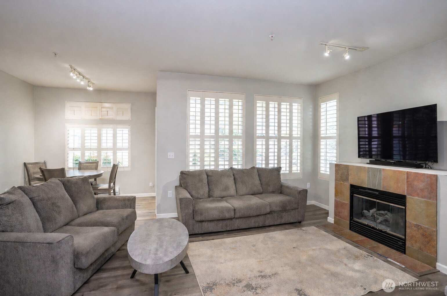 Inviting living area flows seamlessly into the dining space, while large windows bring in abundant natural light.