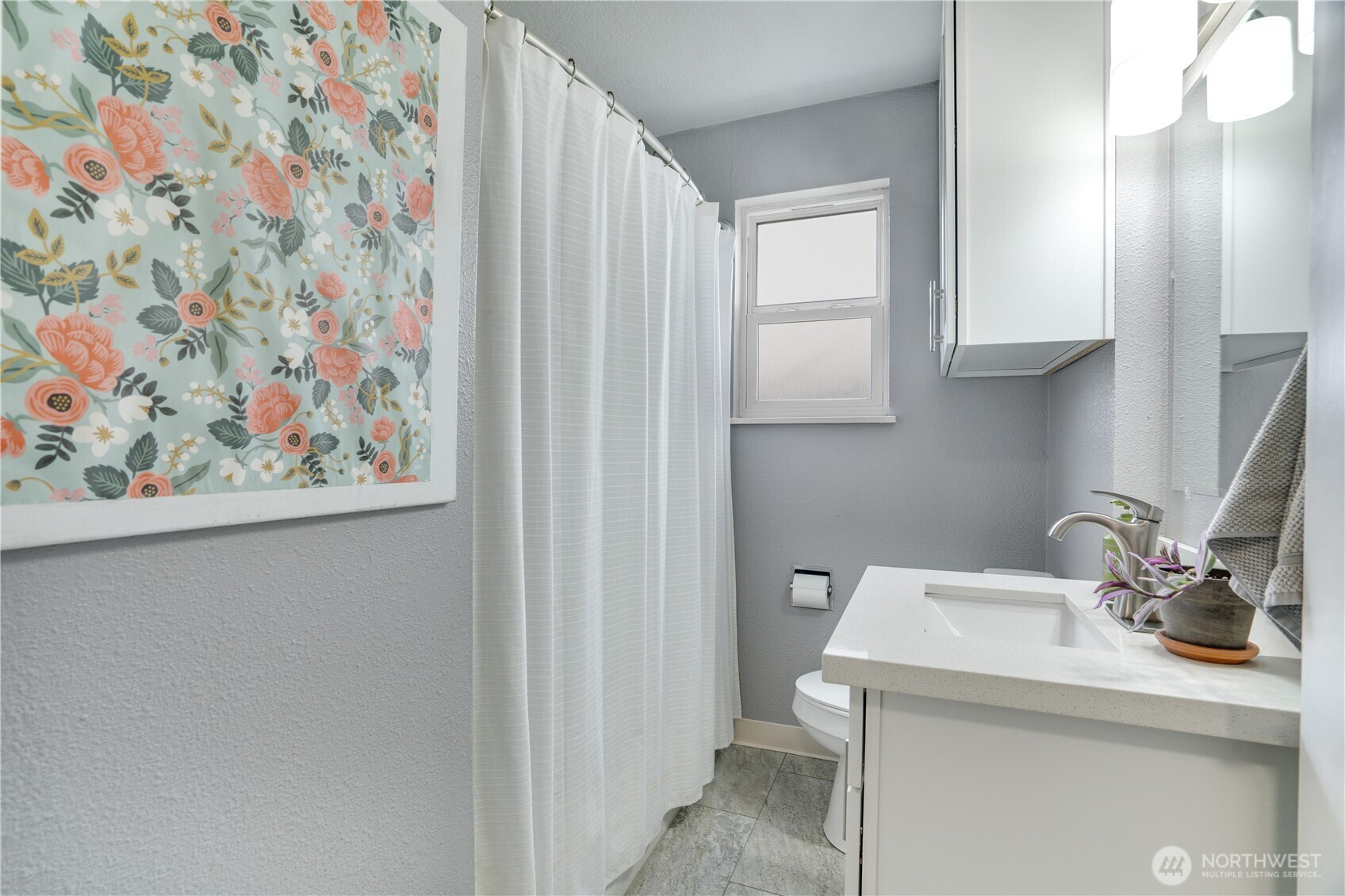 Main floor full bath with tile flooring and quartz countertops