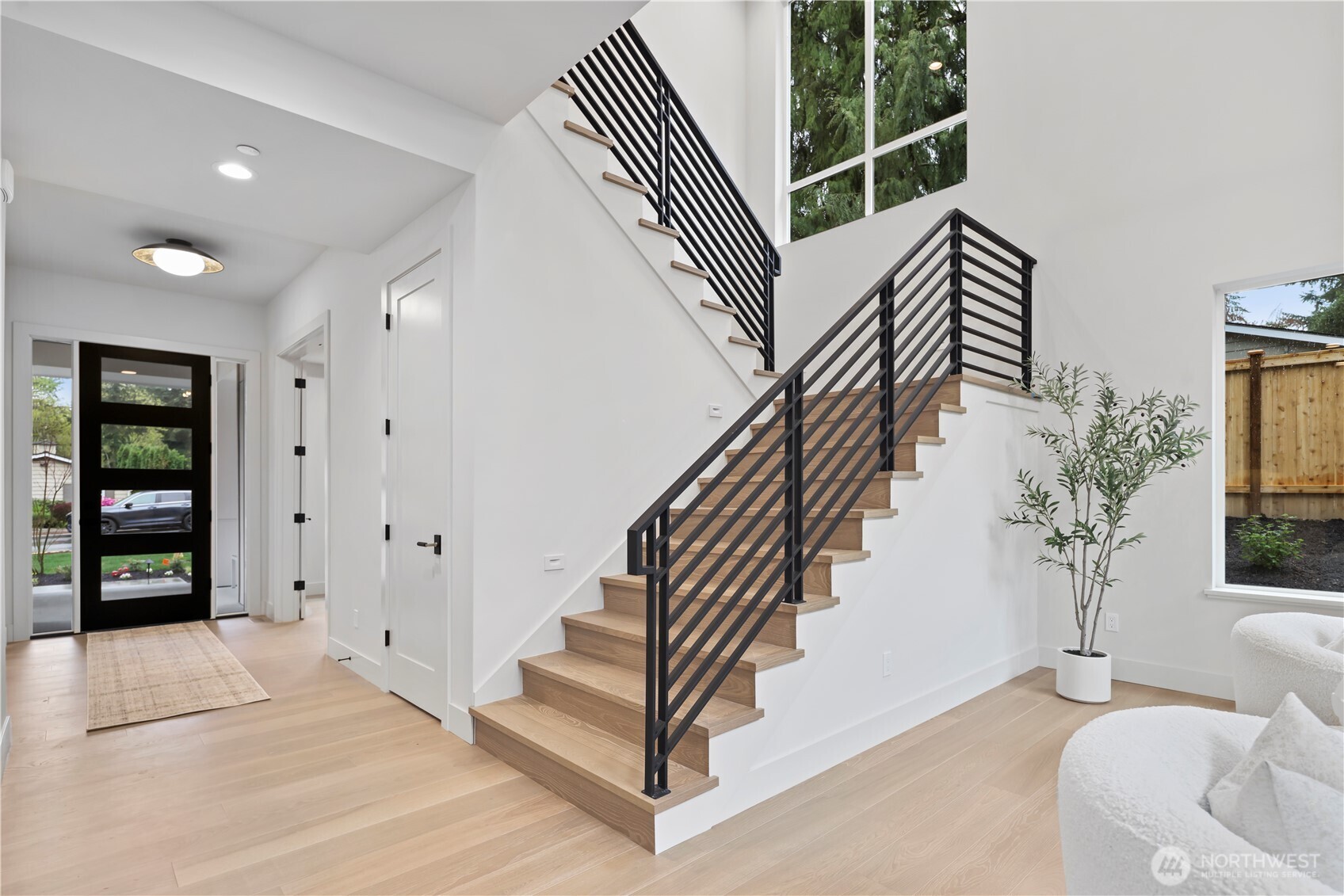 Light-filled stairwell with clean lines and custom fabricated modern railing detail. 10' ceilings on the main level and 9' upstairs. 8' doors throughout the home.