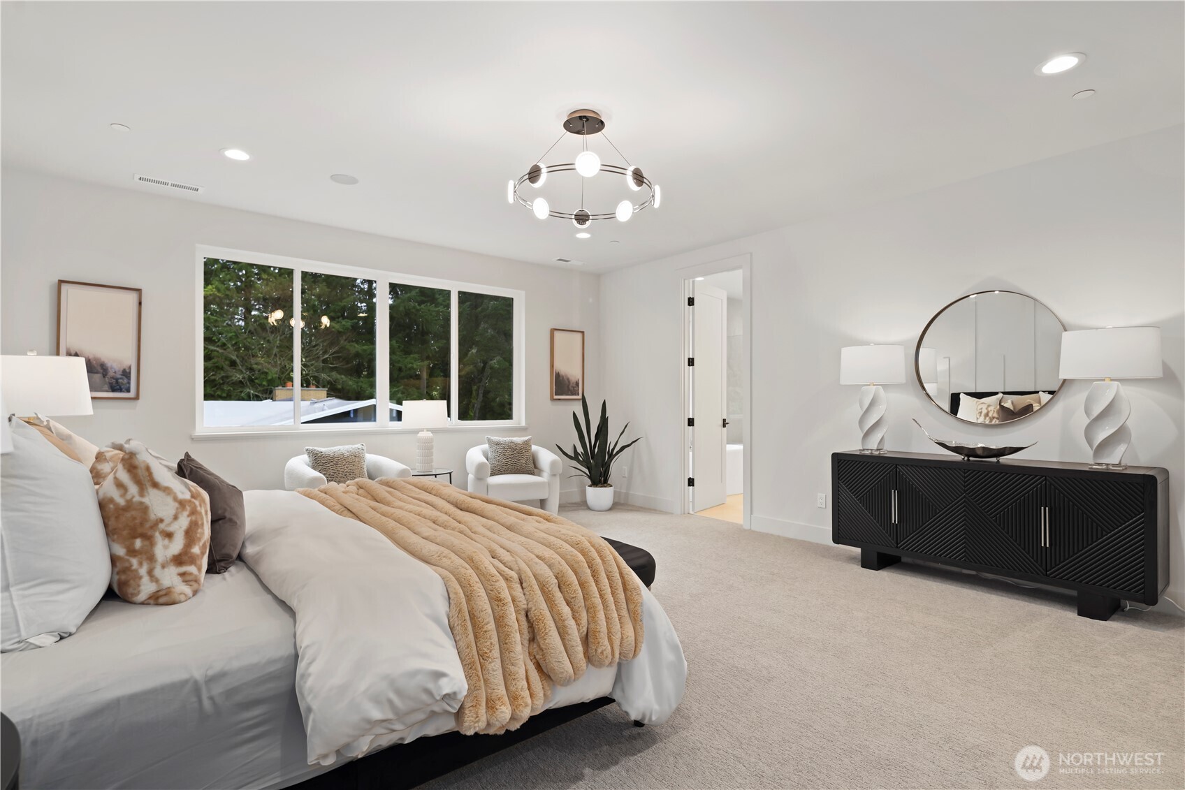 Spacious primary retreat with sitting area and tranquil outlooks.