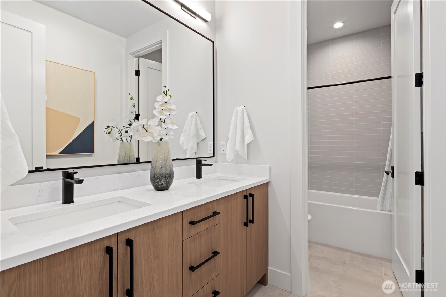 Stylish hall bath with dual vanity and crisp, modern finishes.