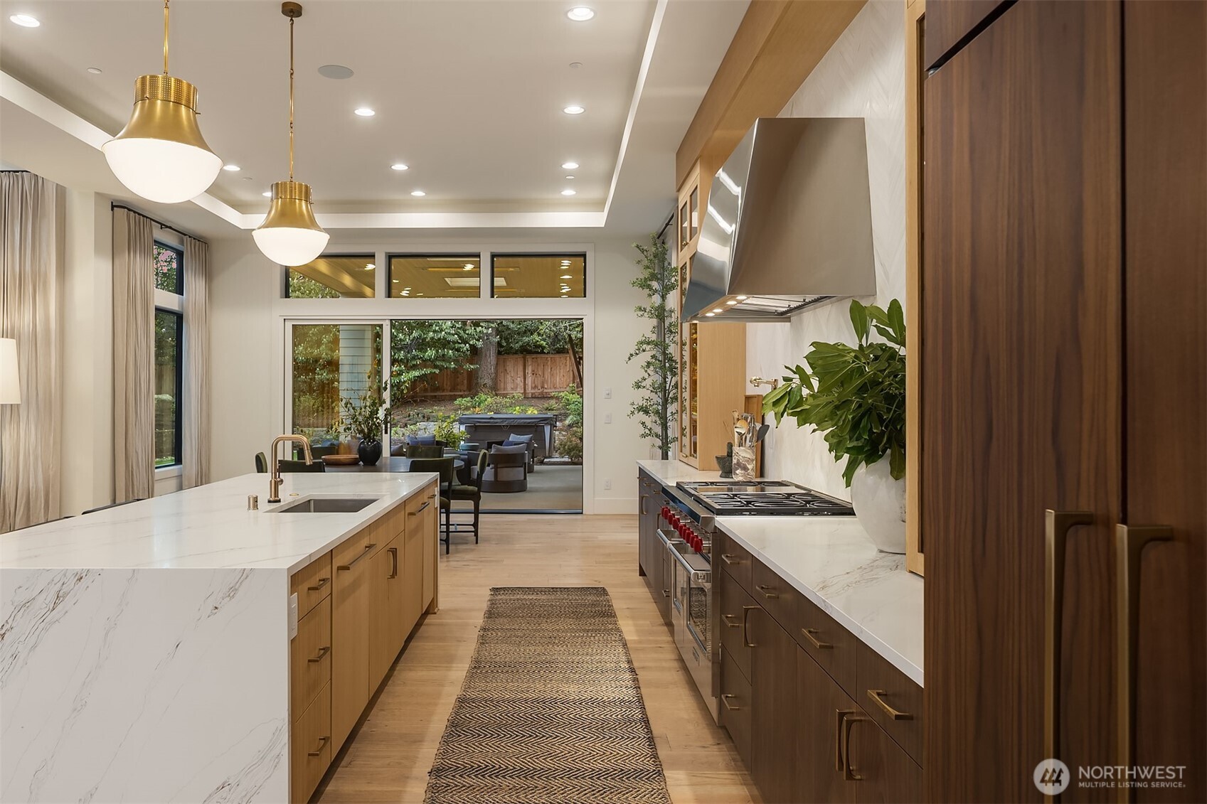 From the Wolf range to the sliding doors and straight out to the covered terrace — the kitchen that connects the whole main floor. Sunday dinner starts here and ends out there.