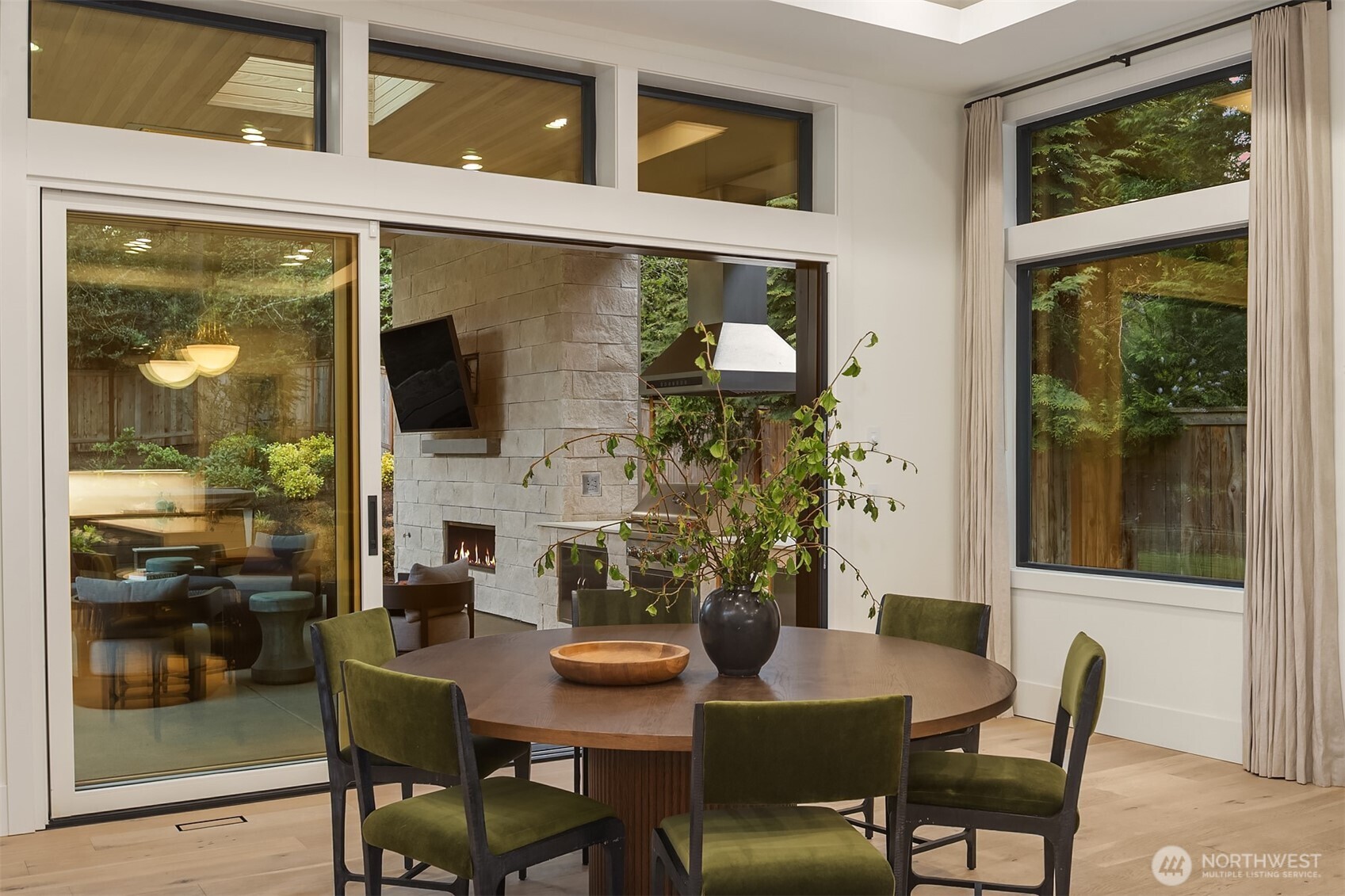Open the doors and dinner moves outside — just like that. The covered terrace, outdoor fireplace, and this dining space were made to work together.