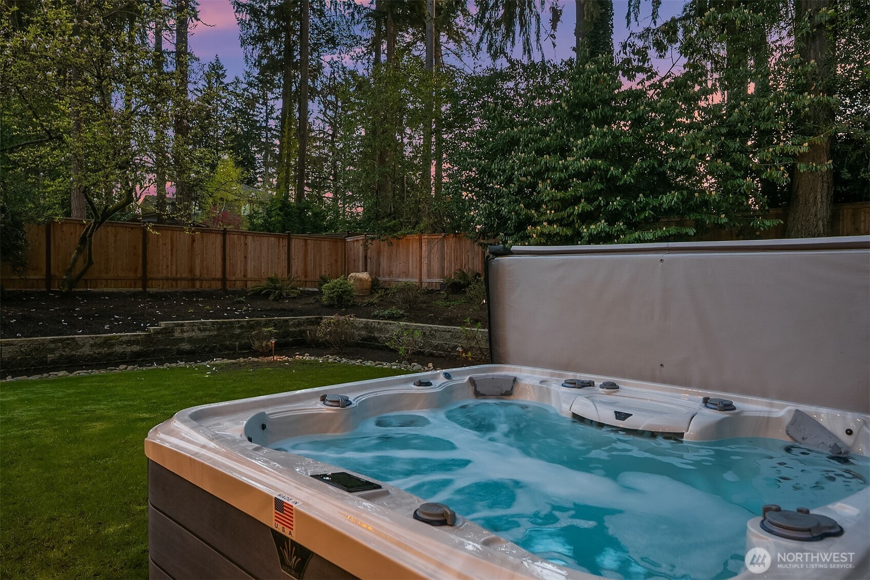 Terraced landscaping, towering evergreens, and a hot tub under an open sky. The backyard that earns its keep on a quiet Wednesday night just as much as a summer weekend.