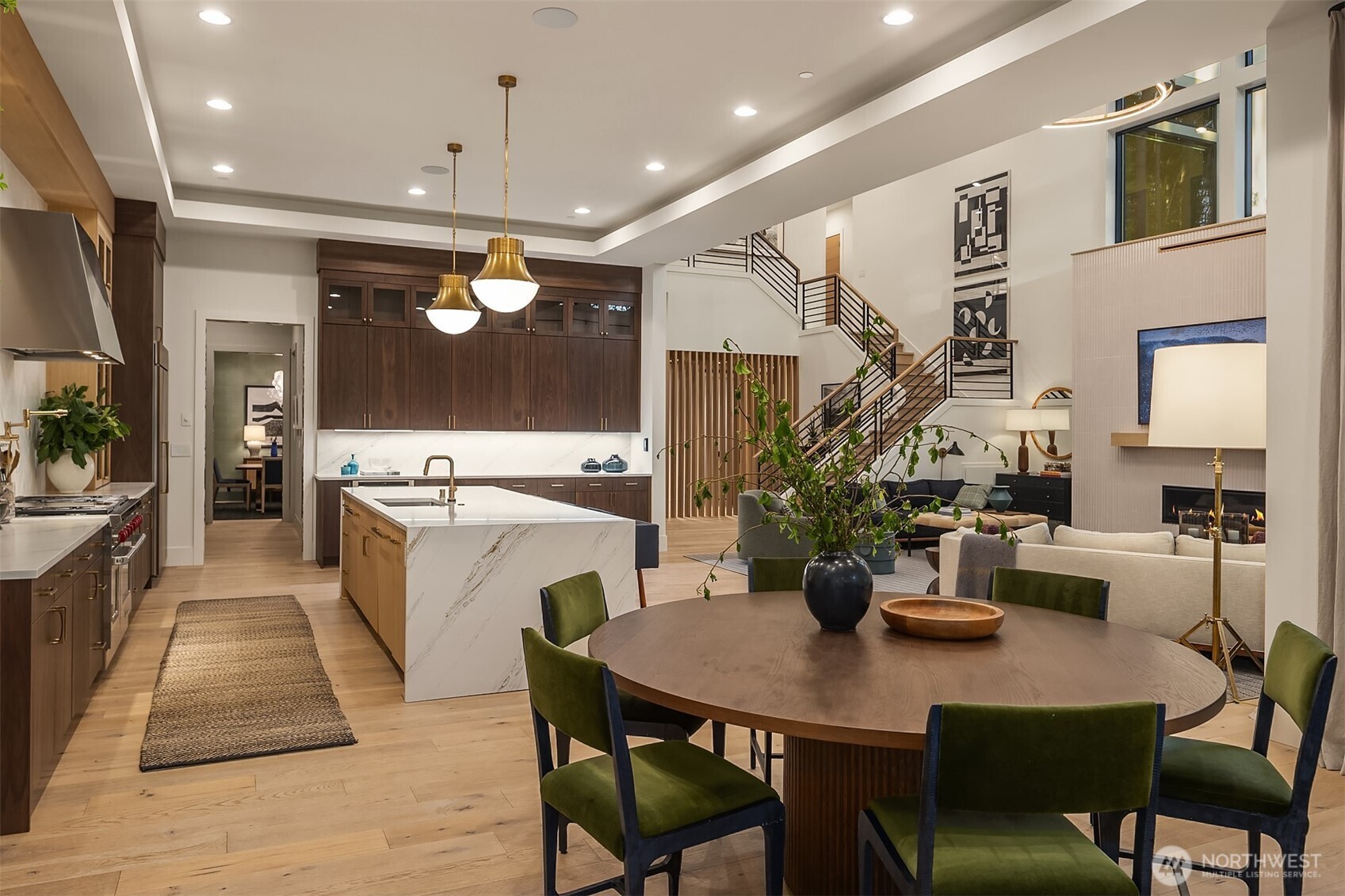 An entertainer's paradise — kitchen, dining, and great room all flowing seamlessly into one another, with the fireplace glowing and the terrace just beyond the glass. The main floor that was built for the people who love having everyone over.