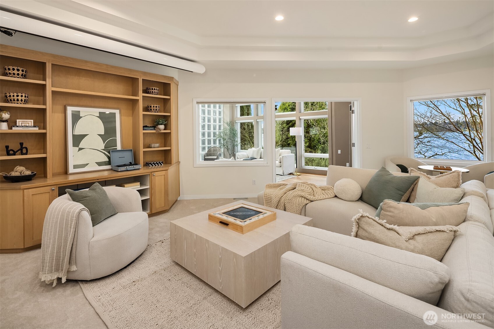 The media room flows naturally into the sunroom, offering easy transition to the outdoor patios and the lake.