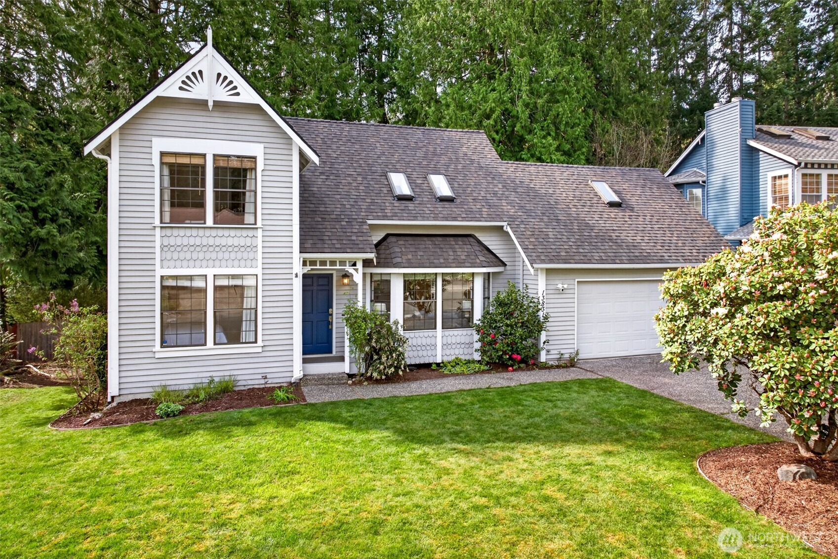 Classic two-story styling with decorative gable trim, shingle accents, and a signature blue door anchors a memorable presence in one of Redmond's most coveted Northshore School District enclaves.