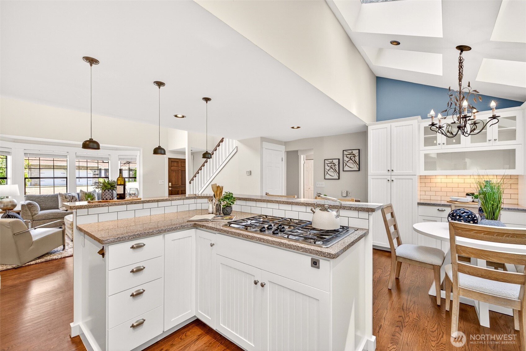 A skylight overhead and bar seating along the island create a relaxed gathering spot, while the built-in microwave combination wall oven and pantry-style storage keep daily life organized and efficient.