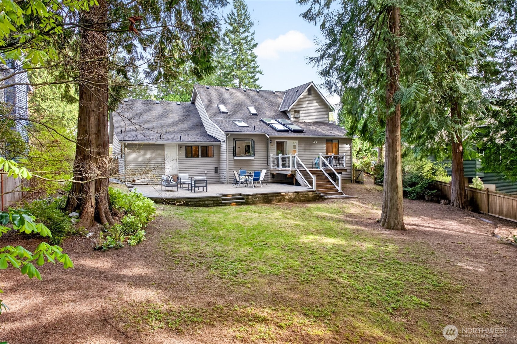 The 10,958 sq. ft. lot opens to a parklike backyard surrounded by towering Pacific Northwest evergreens, offering rare privacy and room to enjoy the outdoors year-round.