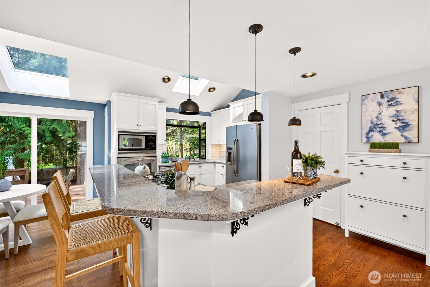 Granite counters, updated white cabinetry, stainless appliances, and pendant lighting come together in a beautifully equipped kitchen designed to inspire everyday cooking and weekend gatherings.