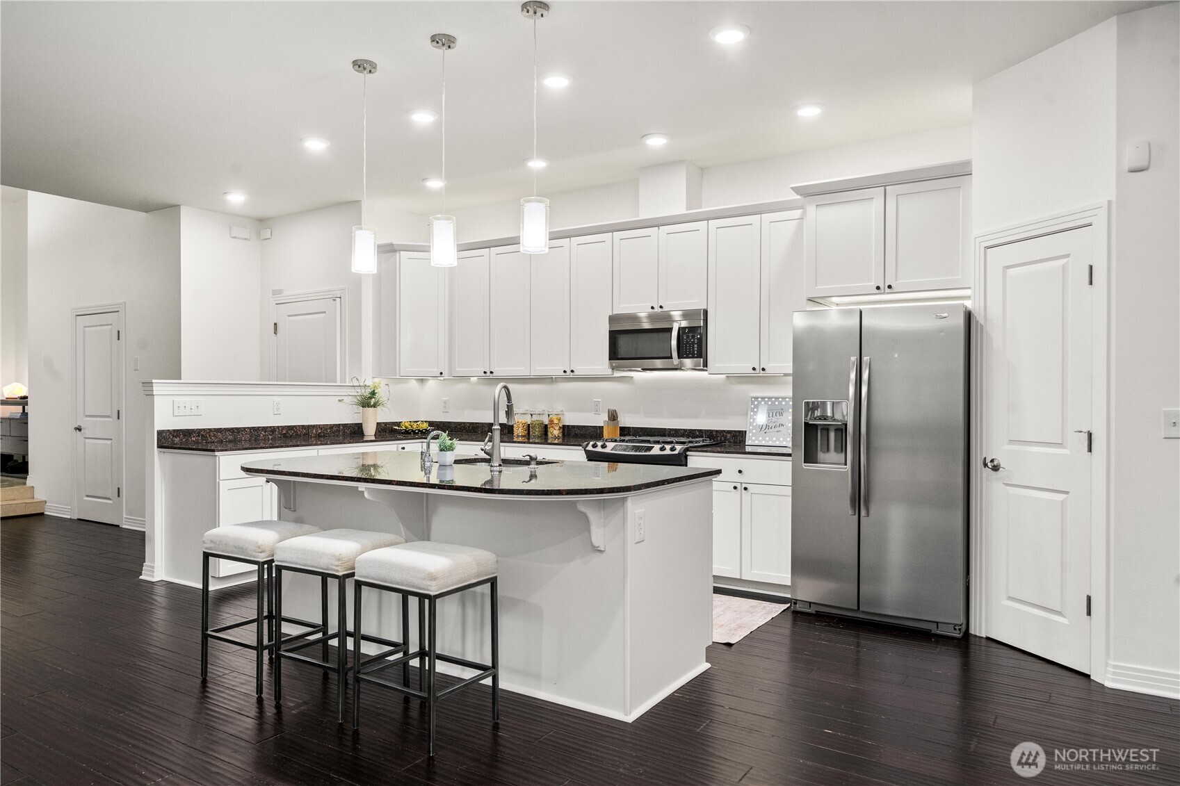 The gourmet kitchen features granite countertops, a statement island, & rich repainted cherry cabinetry