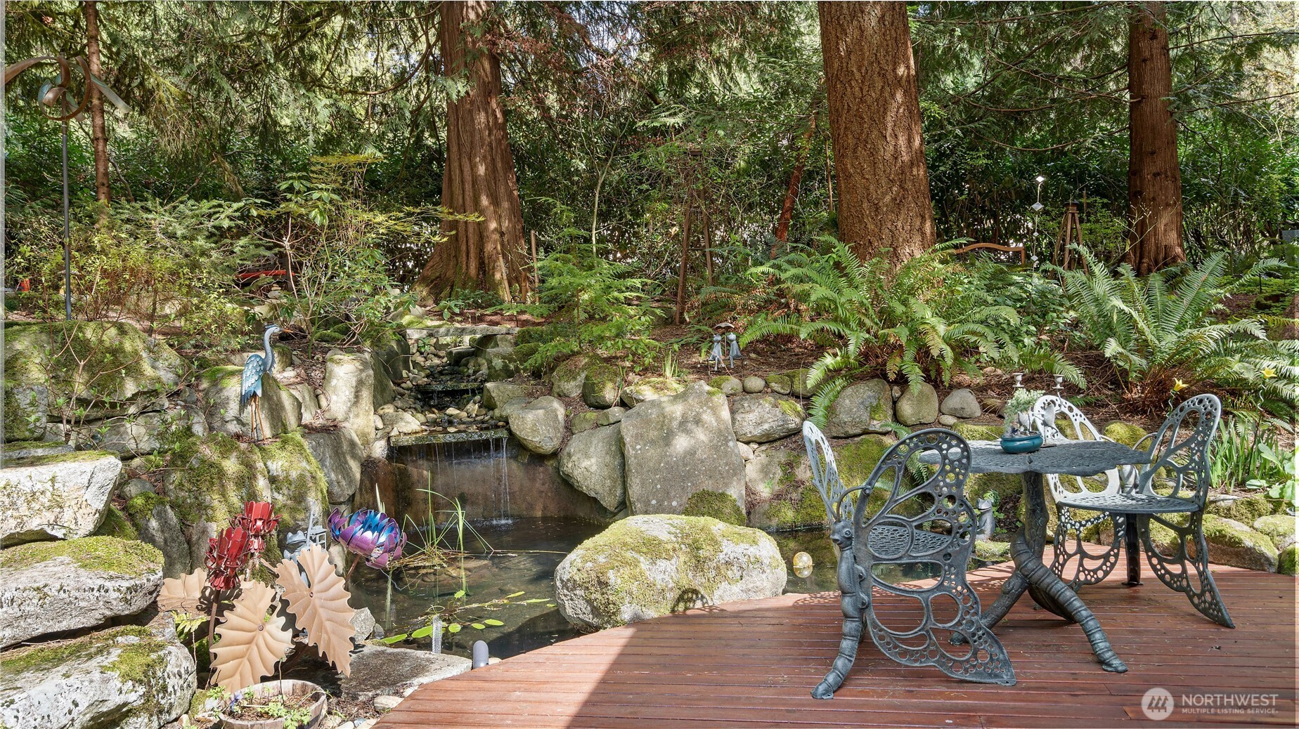 At this end, the deck opens up once again, revealing more stone steps, the outdoor kitchen, and an extraordinary multi-tiered waterfall. The whole scene is so thoughtfully composed, with each element drawing you naturally to the next.
