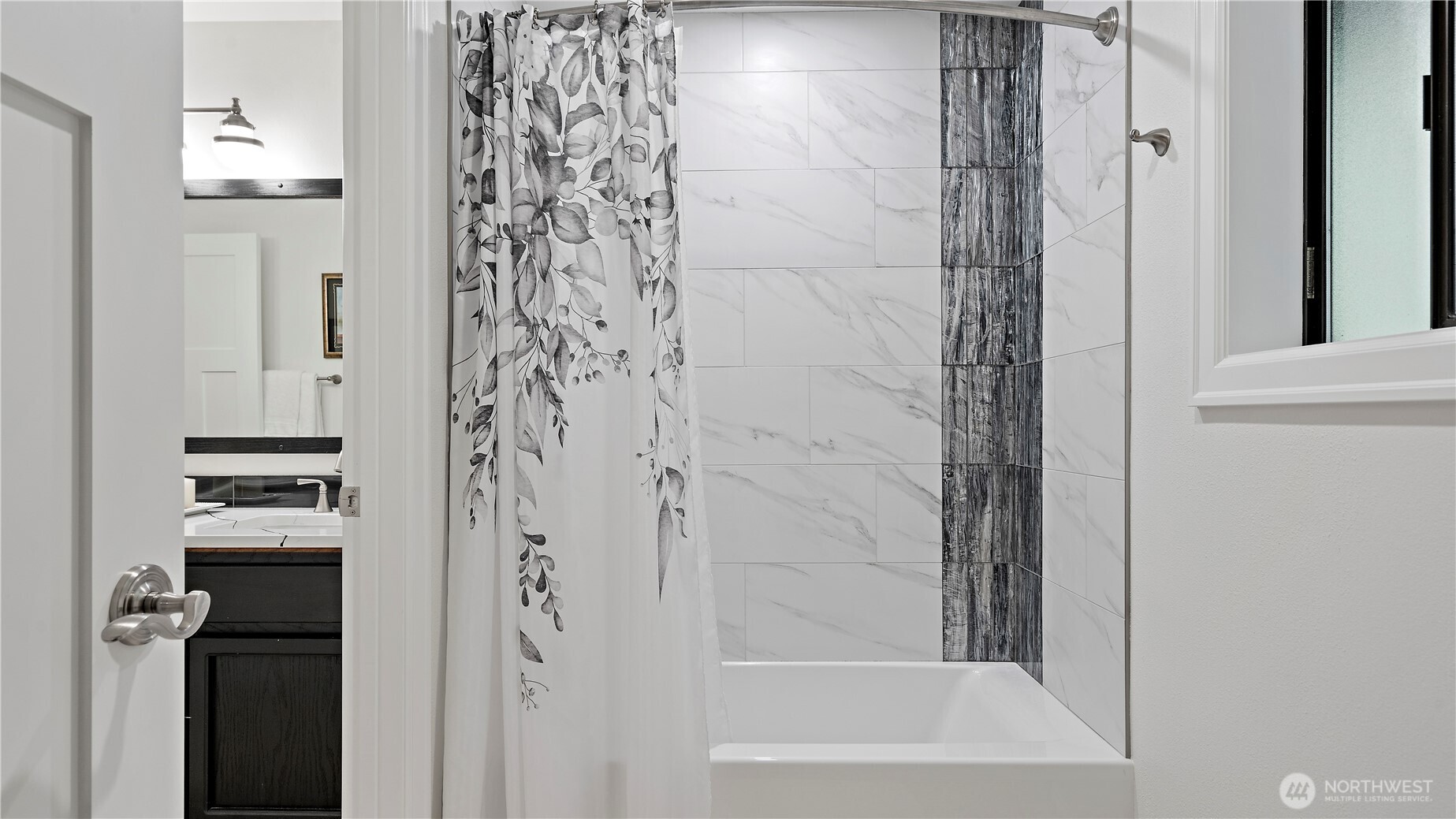 This updated bath was done in such a fresh, polished way. The crisp tile, darker accent surround, and rich vanity tones give the space a clean, current look with just the right amount of contrast.