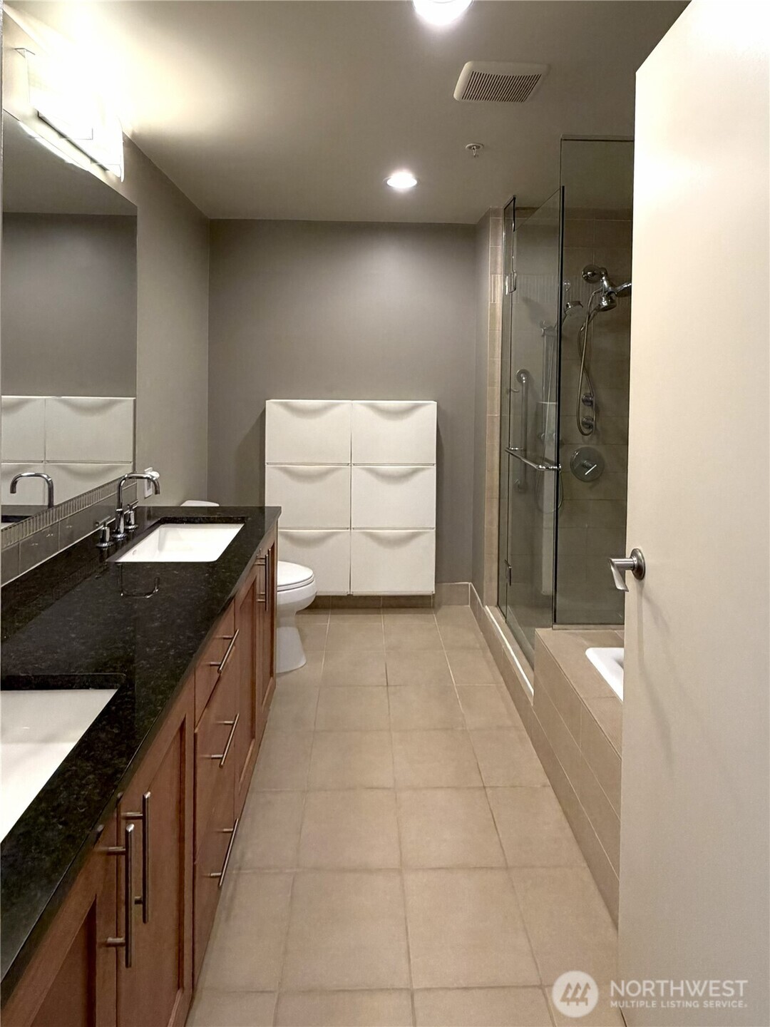 Modern bathroom with sleek vanity and full shower/tub combination.
