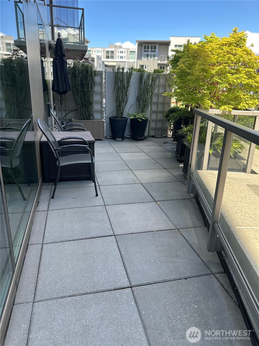 Large private patio with modern tile flooring and open sky views.