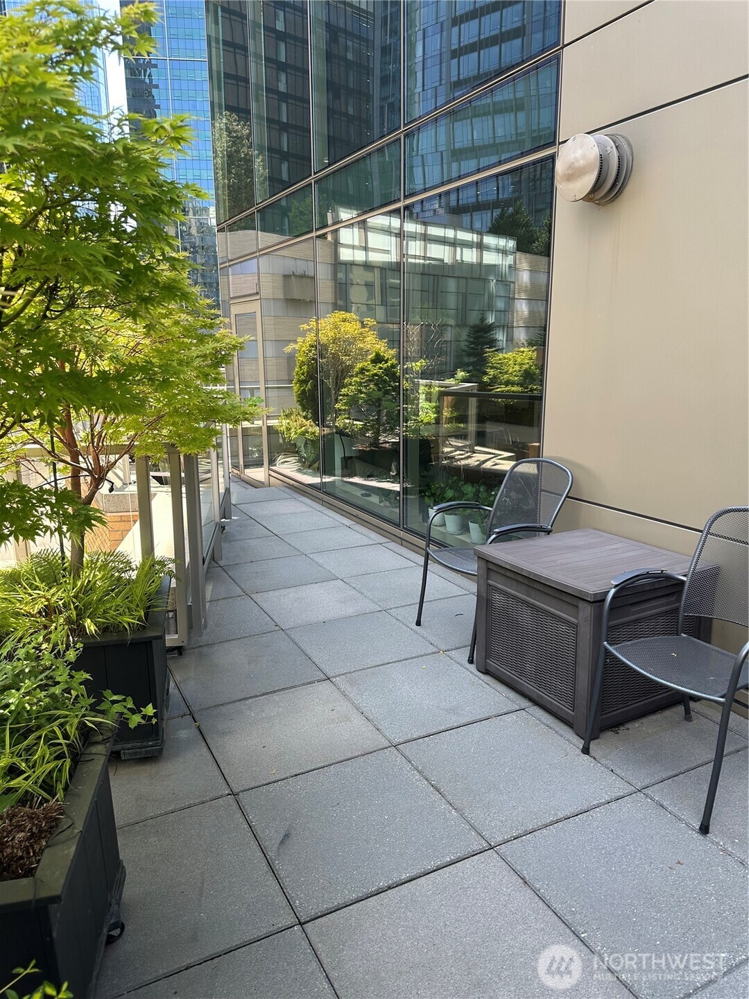 Private outdoor living area with seating and landscaped planters.
