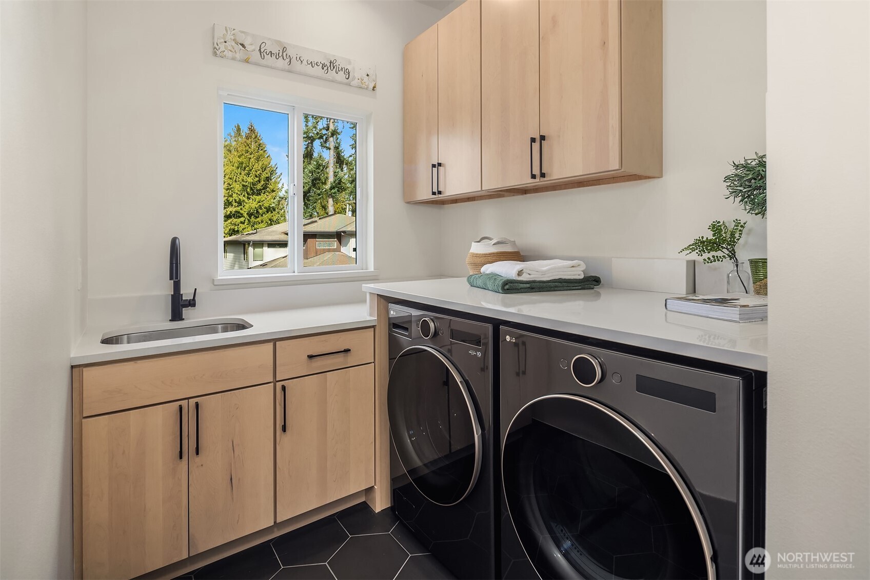 Spacious, main-level laundry room with utility sink and full size washer/dryer