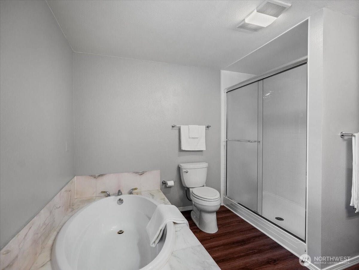 Deep soaking tub and a shower in the primary suite.