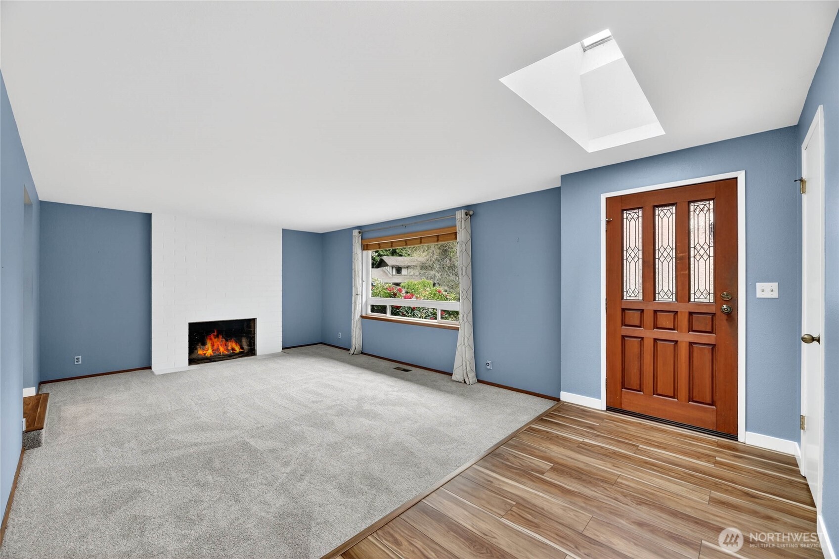 Sunken LIVING ROOM  Large picture window overlooking front yard with wood blinds and curtains  NEW carpet / Easy access to kitchen