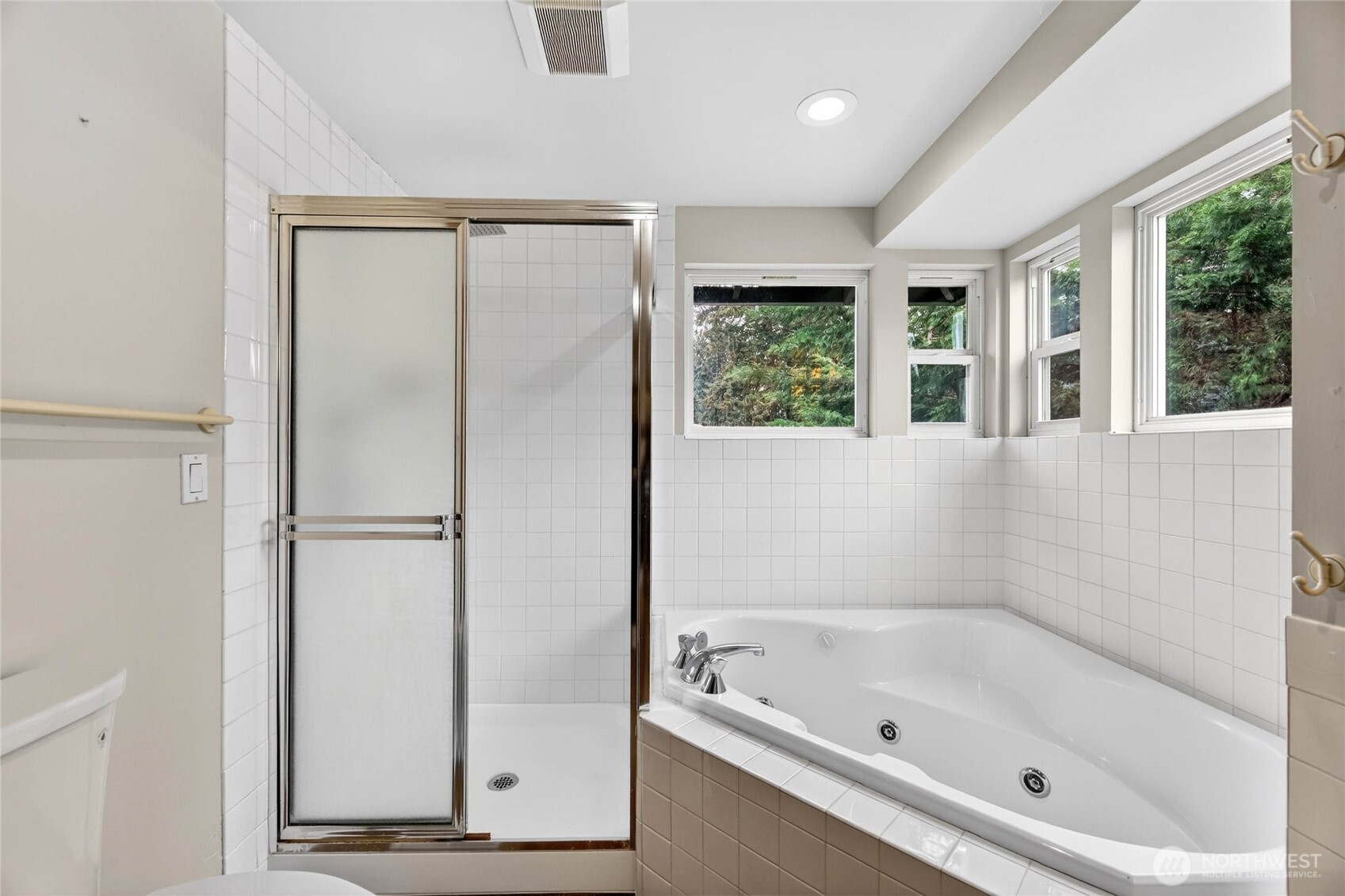 Corner jacuzzi tub with tile surround, and upper window that open for fresh air  New walk-in shower with handheld and rain shower head / Tile surround / Glass block accent wall