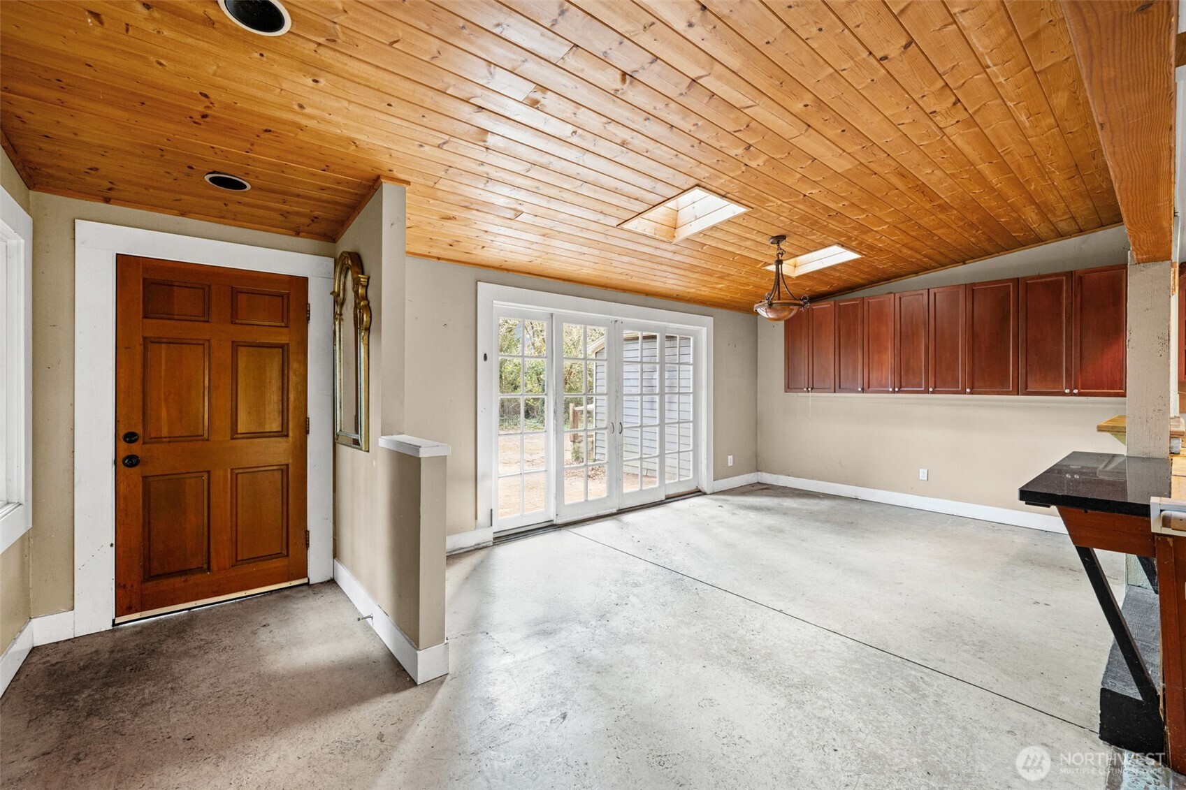 Vaulted wood-paneled ceilings and skylights fill the space with natural light and character. Open layout provides a great canvas for modern updates and customization.