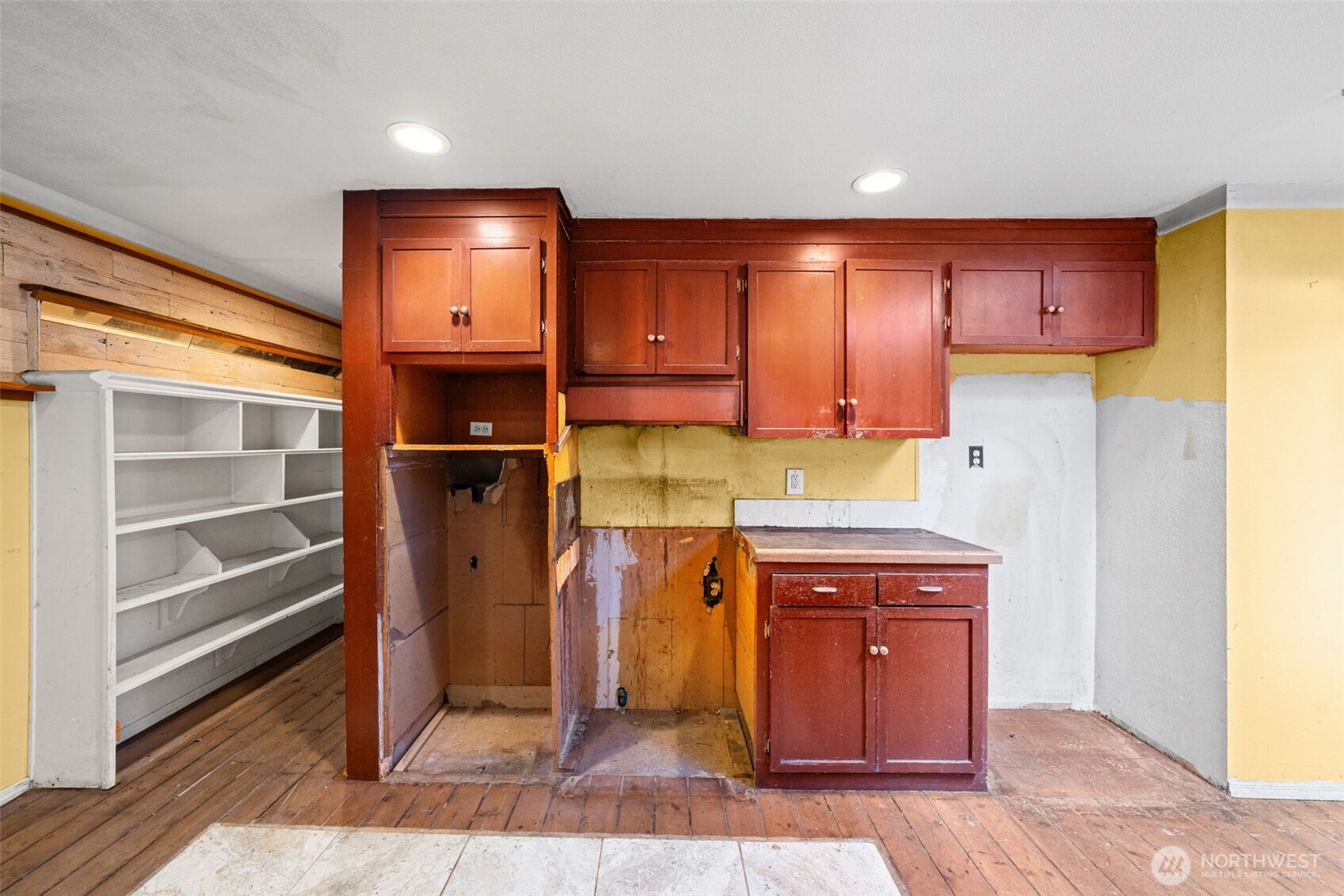 Kitchen area partially prepped for renovation, offering a head start for your redesign. Adjacent shelving space could be transformed into a walk-in pantry or expanded storage.