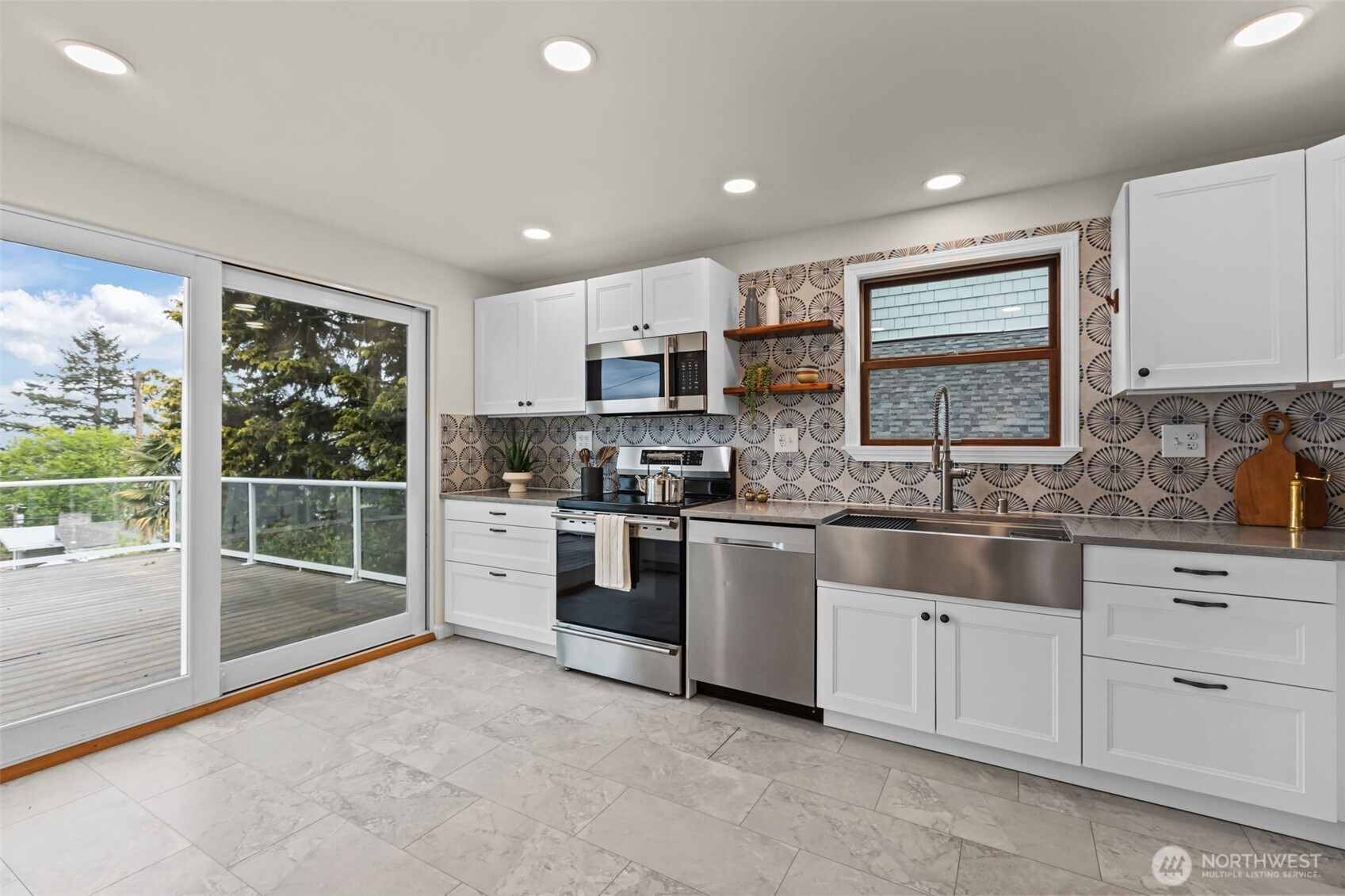 Slider opens to stunning back deck.A large window above the farmhouse-style sink floods the kitchen with natural light, creating a warm and welcoming focal point.