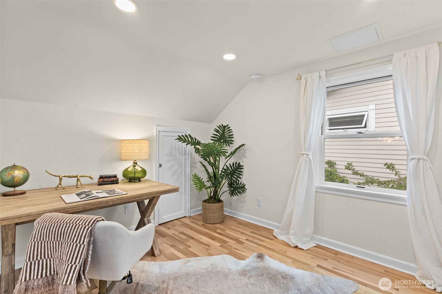 Loft space serves as airy place for home office, pelaton or book/play nook.