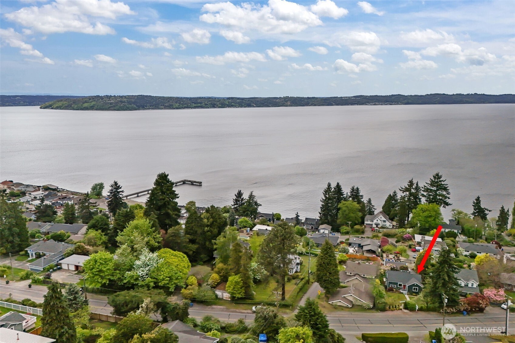 The water view includes dynamic Northwest scenery—passing boats, changing tides, shifting cloud patterns, and seasonal color in surrounding greenery.