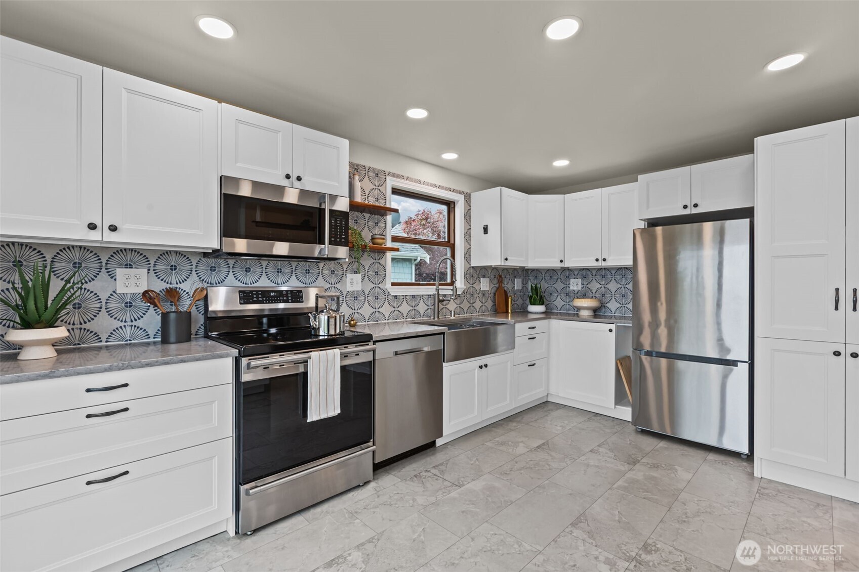 Sleek stainless steel appliances add a modern, upscale touch, while the eye-catching patterned backsplash brings personality and visual interest throughout the room.